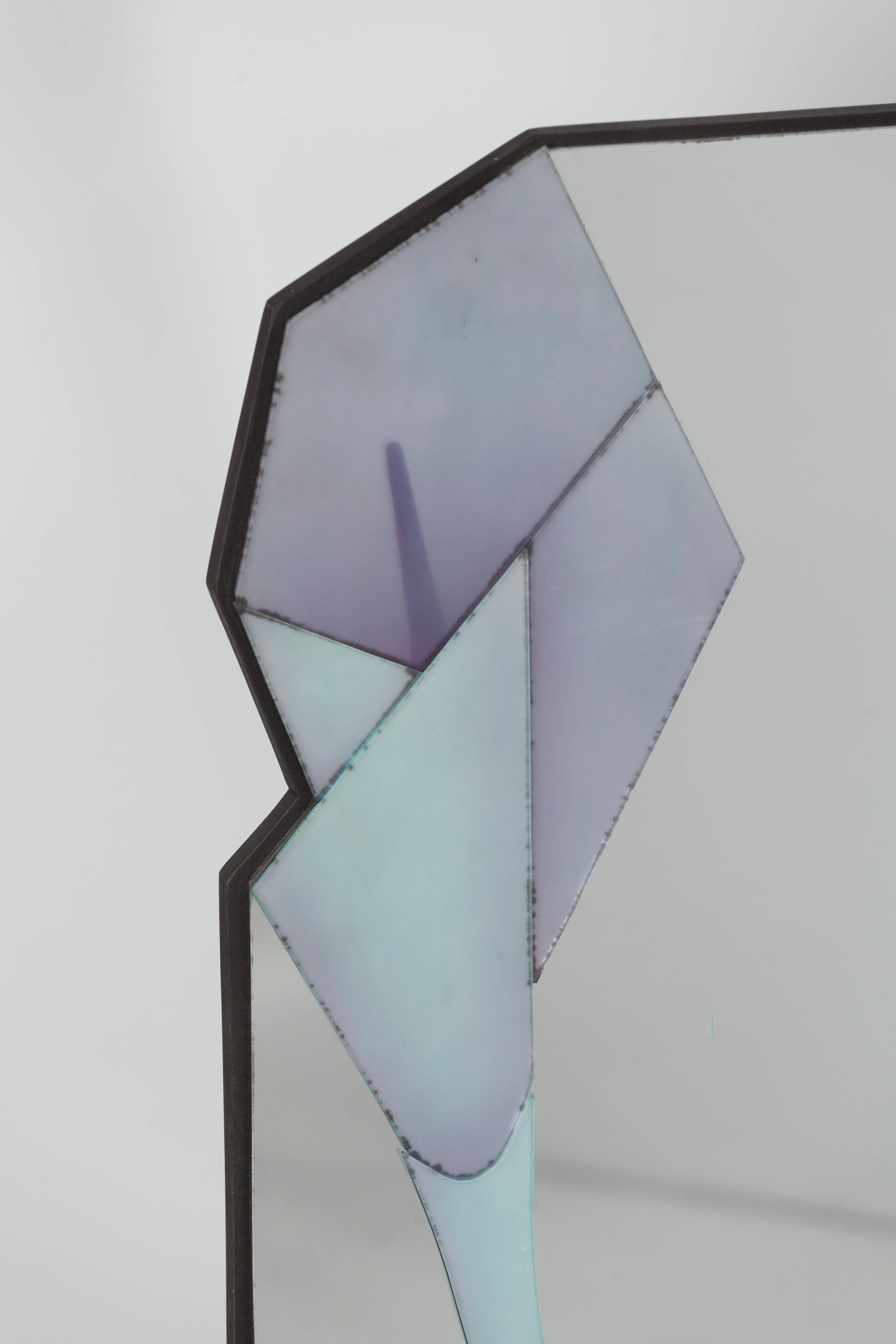 Miroir mural asymétrique avec plusieurs couches différentes créé par David Marshall.
David Marshall conçoit et fabrique des accessoires de meubles depuis 1972, en se spécialisant dans les miroirs sculptés et colorés à la main. Tous les miroirs sont