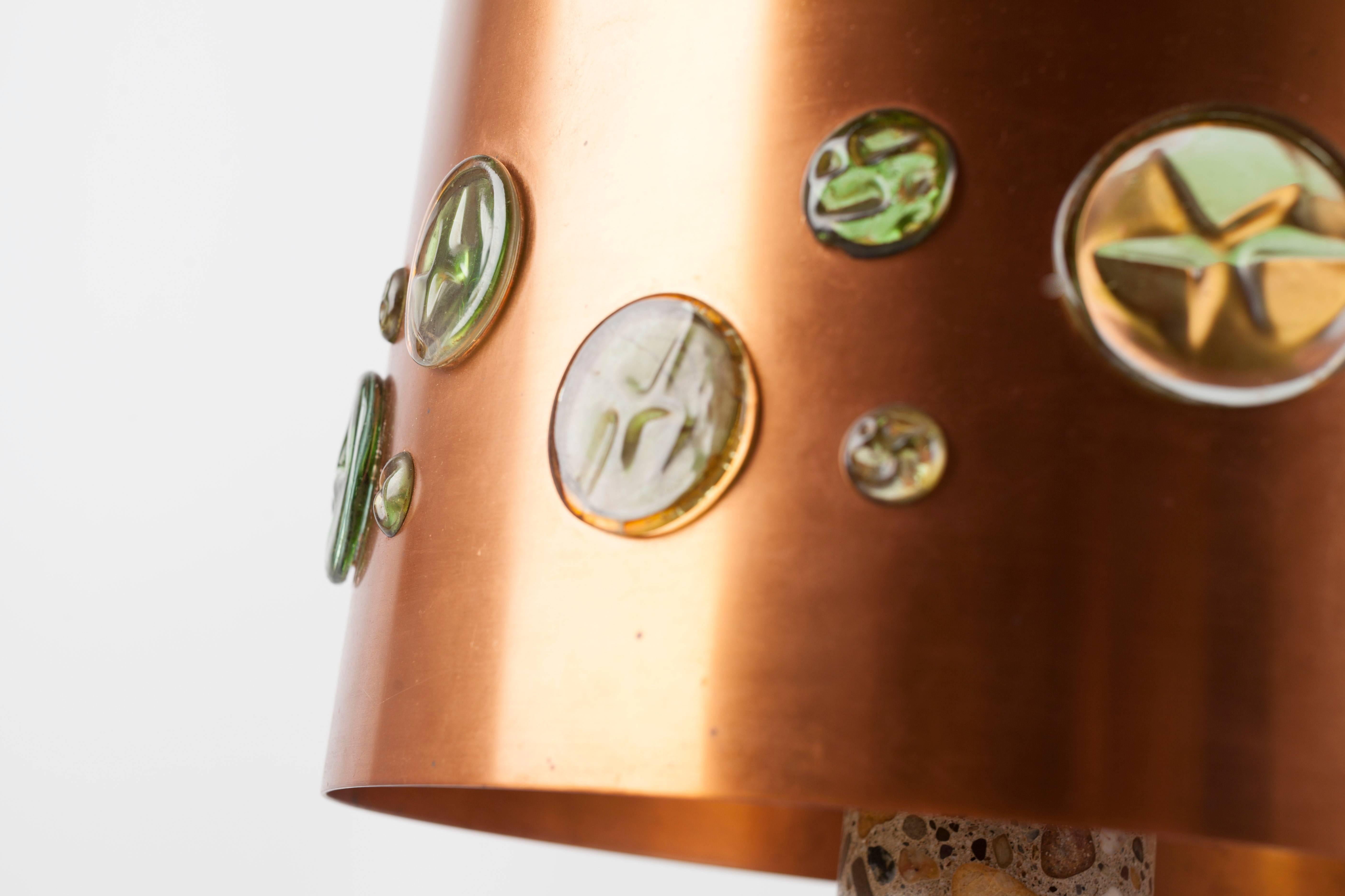 Table lamp designed by Nanny Still for RAAK, Amsterdam. Rare and very heavy piece.

The round base is made of black marble (diameter 23 cm / appr. 9 inches) carrying a terrazzo stick that is topped by a shade made of copper with multicolored glass