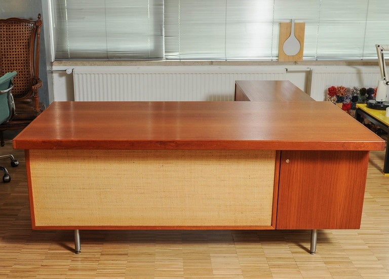Impressive Executive Desk with Return in the style of George Nelson. In addition to the beautiful wood the desk has two cane modesty panels. 

The desk has two drawers plus a small pencil drawer. In addition the return has two sliding doors with