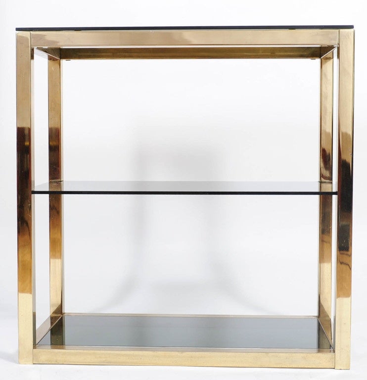 Etagère Hollywood Regency in ottone e vetro creata da Renato Zevi.
Questa étagère è un elegante mix di ottone lucido e vetro nero fumé.
Un ottimo espositore per i tuoi cari soprammobili.