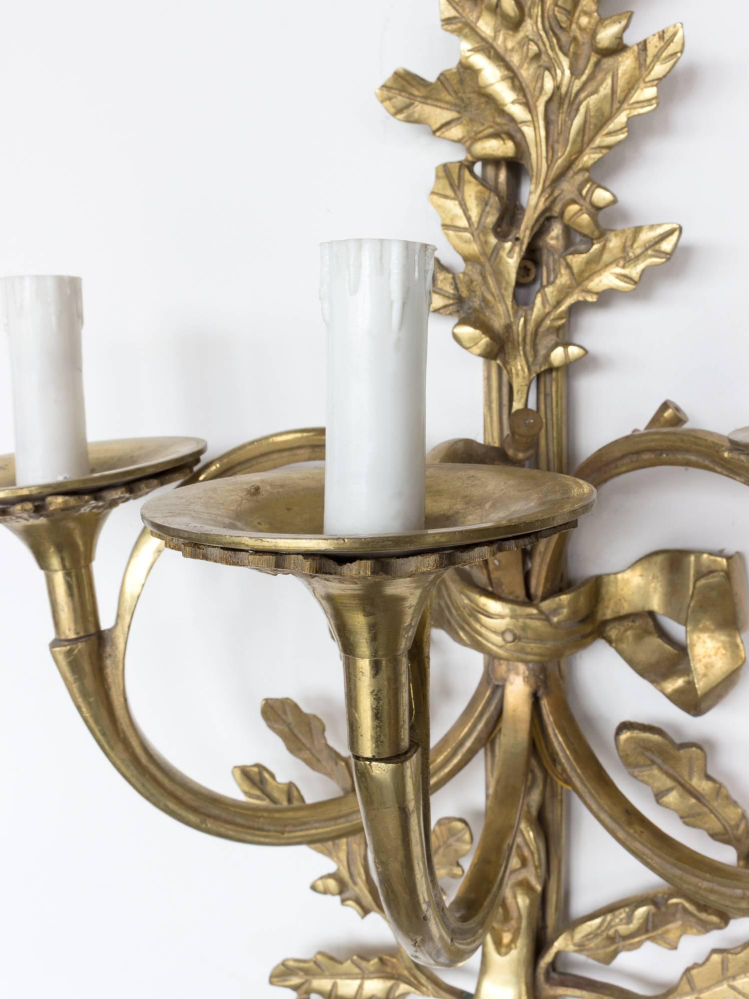 19th century gilded bronze French wall sconces.

Ornate Louis XVI style wall lights from the late 19th century (circa 1890s) from an apartment in Paris.

The gilded bronze design features ornamentation of foliage, tassels and bows. The fixtures