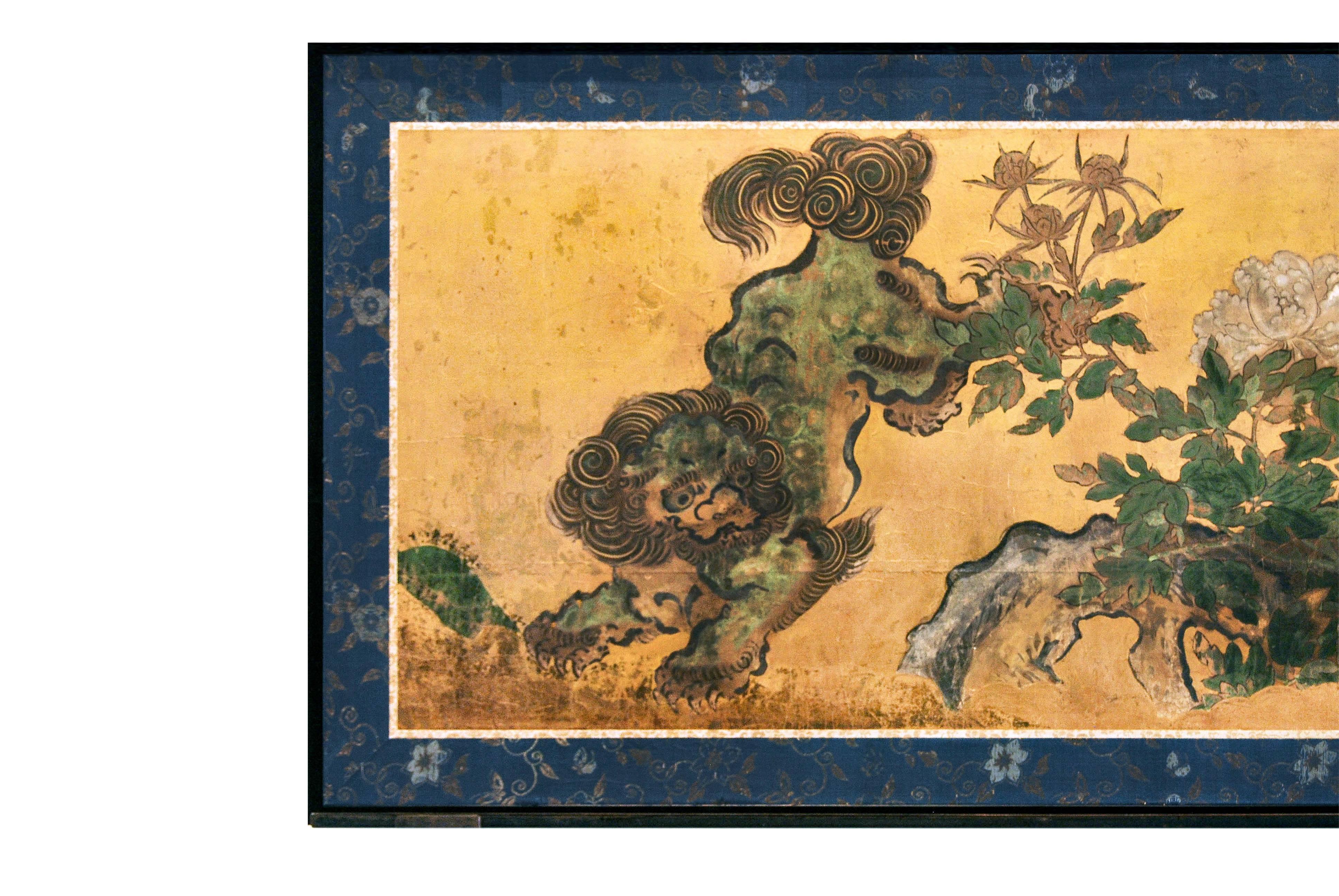 Antique Japanese Kano school two fold screen with a well painted scene depicting a pair of 'shi-shi' Buddhist guardian lions in animated poses frolicking amidst a rocky landscape interspersed with white tree peony flowers, early Edo period, circa