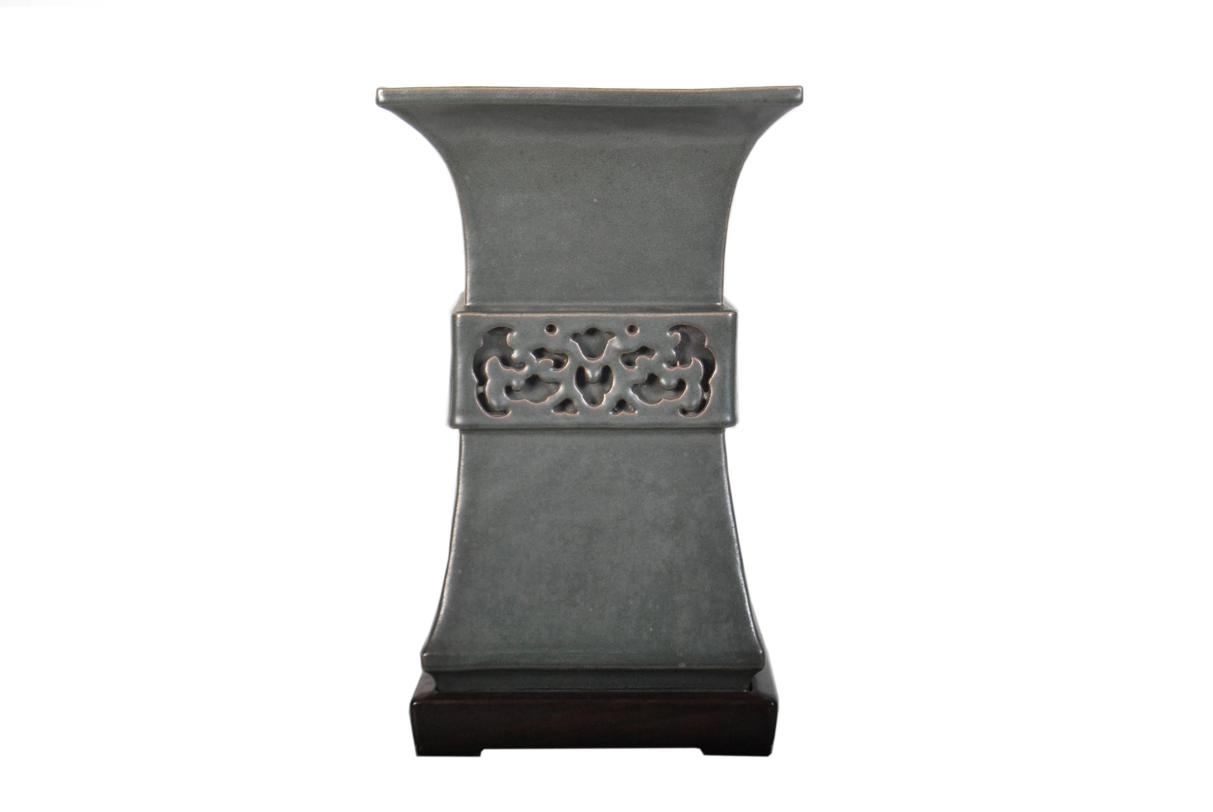 Large archaic Chinese style ceramic vase by Ito Tozan I (1846 - 1920) of elegant flaring form with a pierced double layered band around its midsection, glazed a dark metallic spinach green and with an accompanying fitted rosewood stand original to
