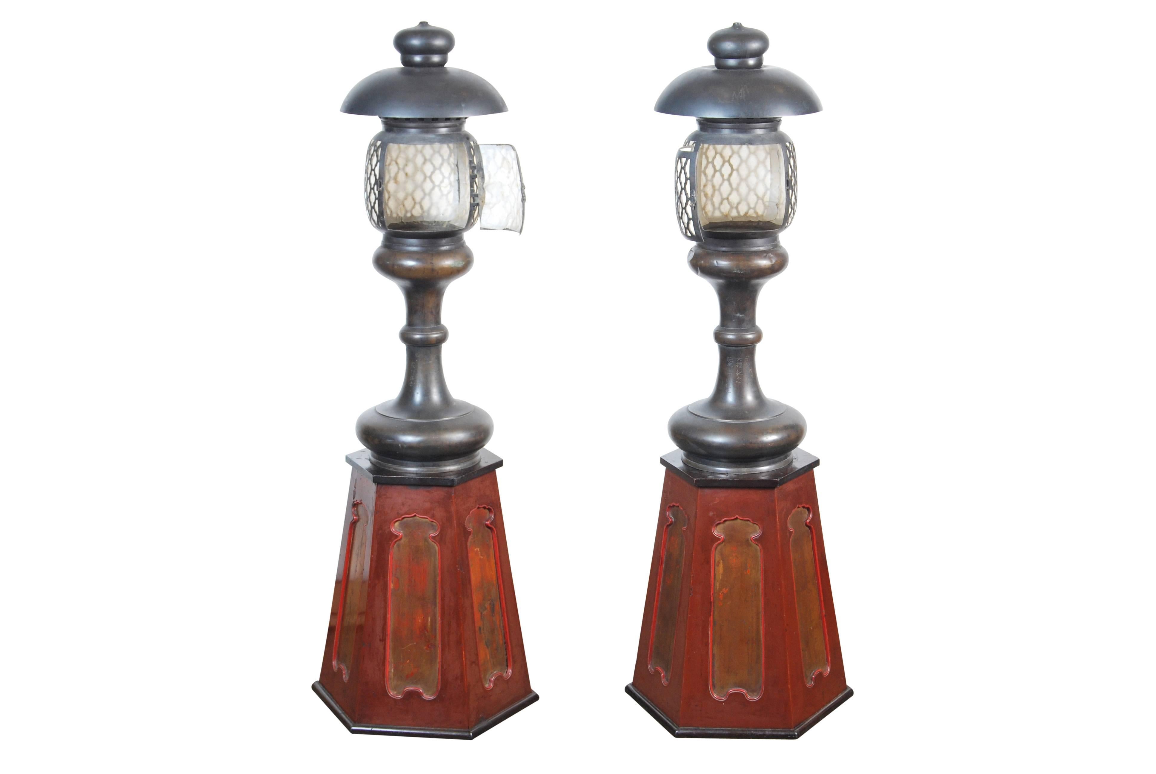 Rare pair of antique Japanese cast bronze Shinto Shrine lanterns paired with their original giltwood and lacquered flaring hexagonal pedestals, late Meiji to early Taisho period, early 20th century. Dimensions: Lanterns: H 90cm x D 33cm. Stands: H