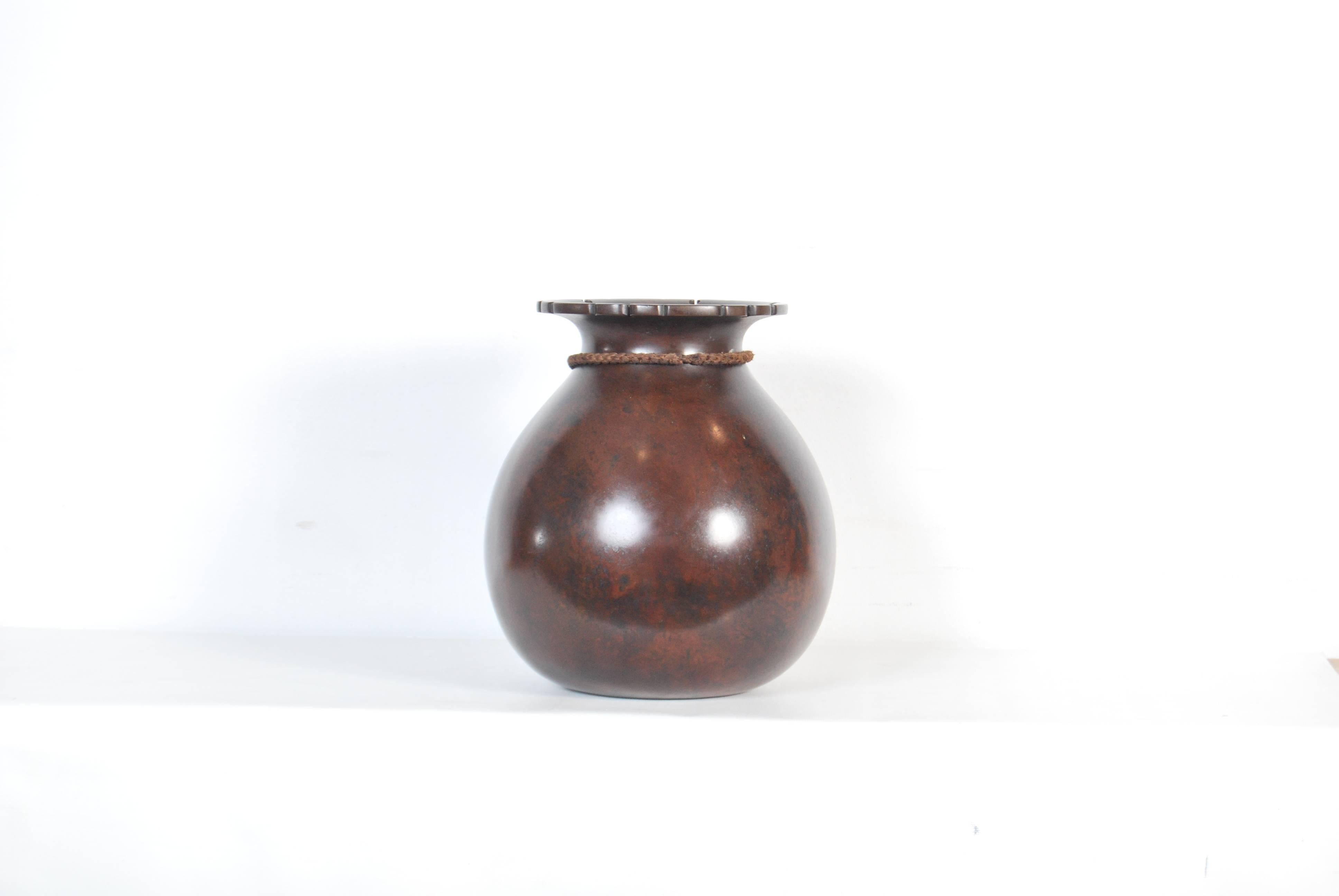 Unusual Japanese cast red bronze vase of bulging form modelled on a coin filled money bag, the surface deeply patinated to a dark reddish black, with signature to base, late Meiji - early Taisho period, circa 1900-1920.

Dimensions: H 32cm x D