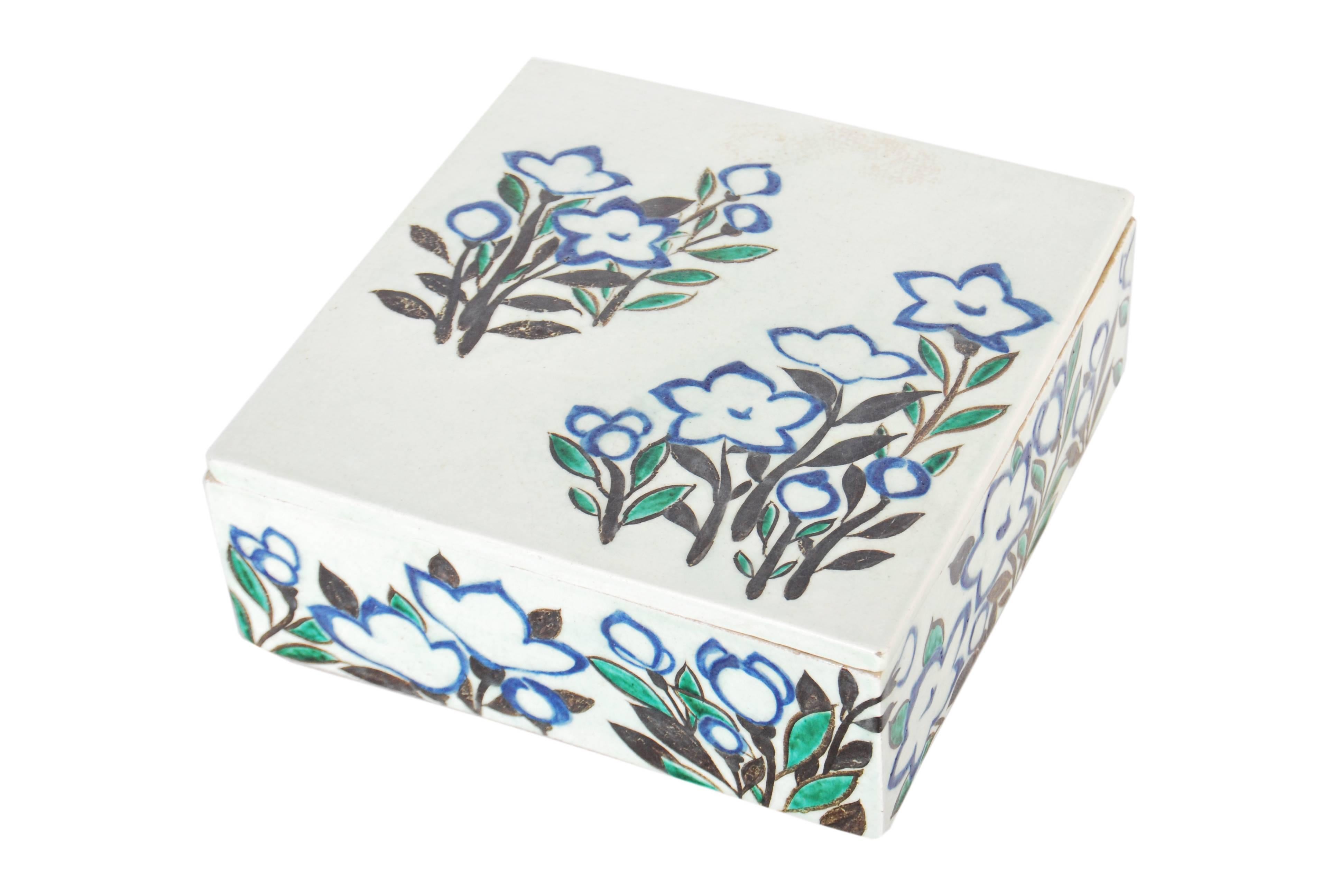 Japanese pottery covered box in the style of Ogata Kenzan, with a freely brushed design of flowers spread across its sides in tones of black, blue and green, Taisho period, circa 1920

Signature to base (not yet translated)

Dimensions: H 7.5cm x W