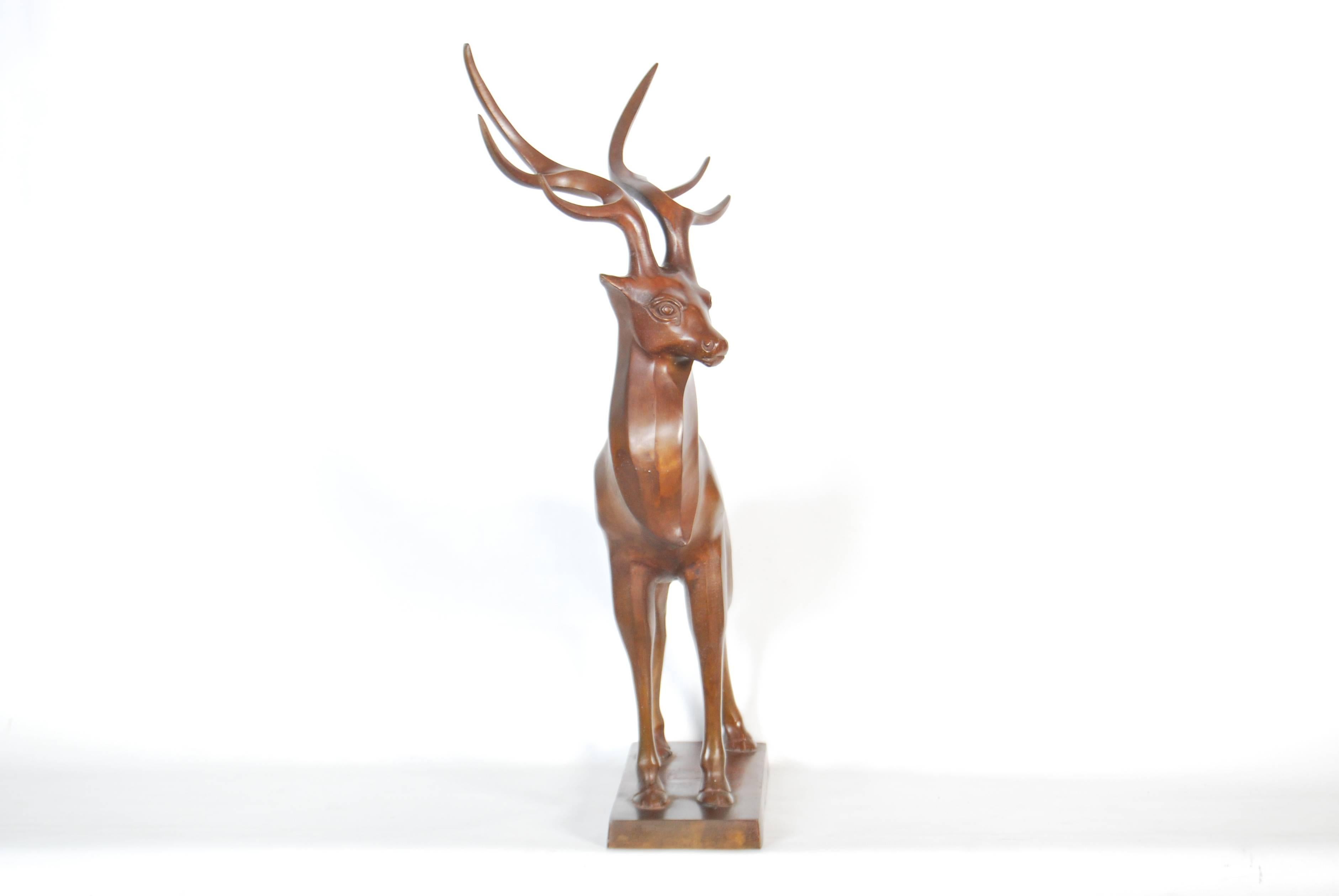 Vintage Japanese cast bronze sculpture of a standing deer, the whole modeled in a bold almost Art Deco style and finished in a dark caramel toned patina, Showa period, circa 1960s.

Acknowledged fault: base has a small indent in the center that