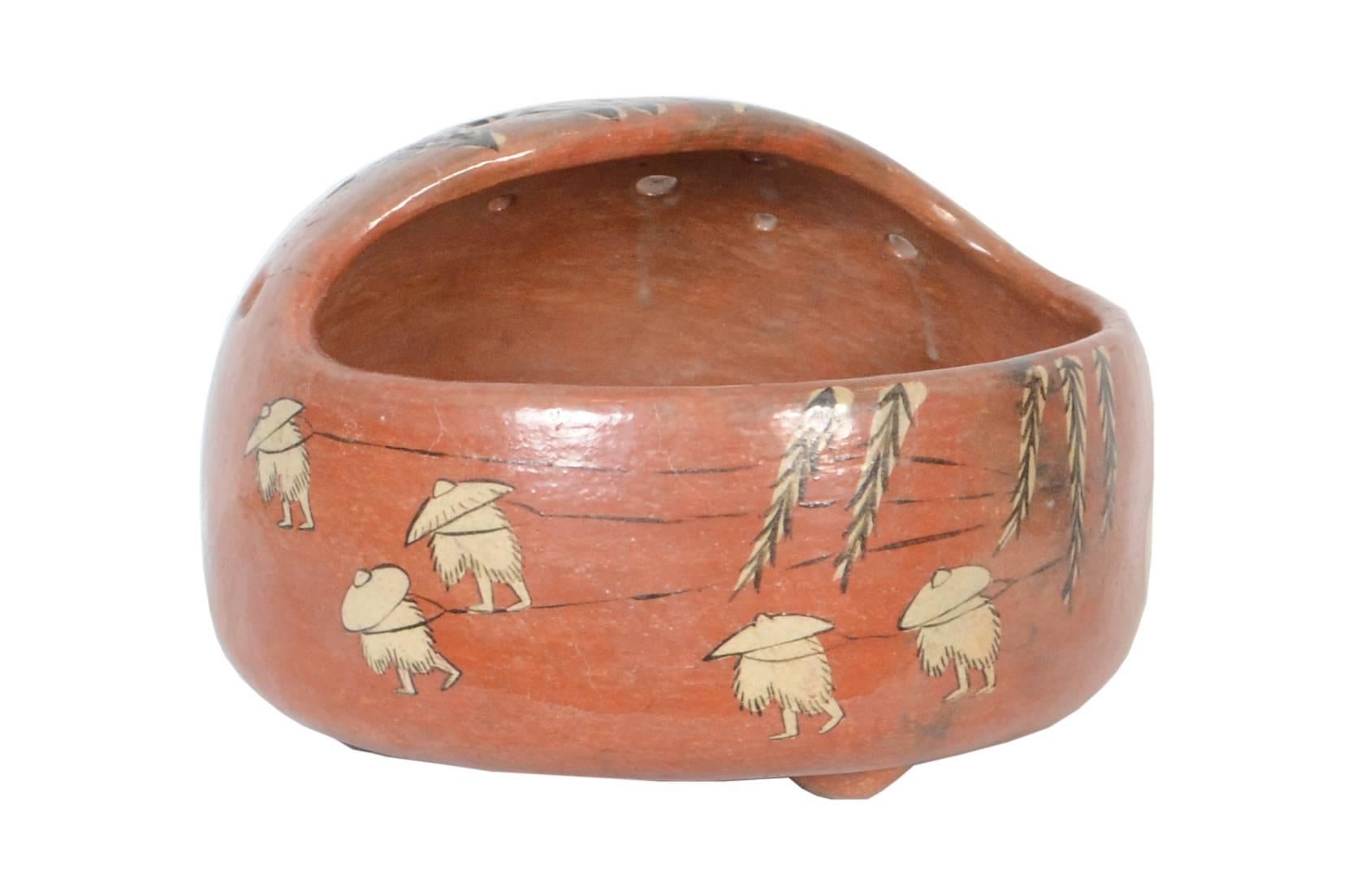 A furo tearoom brazier by Raku Kichizaemon XI Keinyu (1817-1902) decorated in bold style over a brick red glaze. The classical scene depicts men in ‘mino’ straw raincoats pulling a barge up river under the overhanging branches of an ancient willow