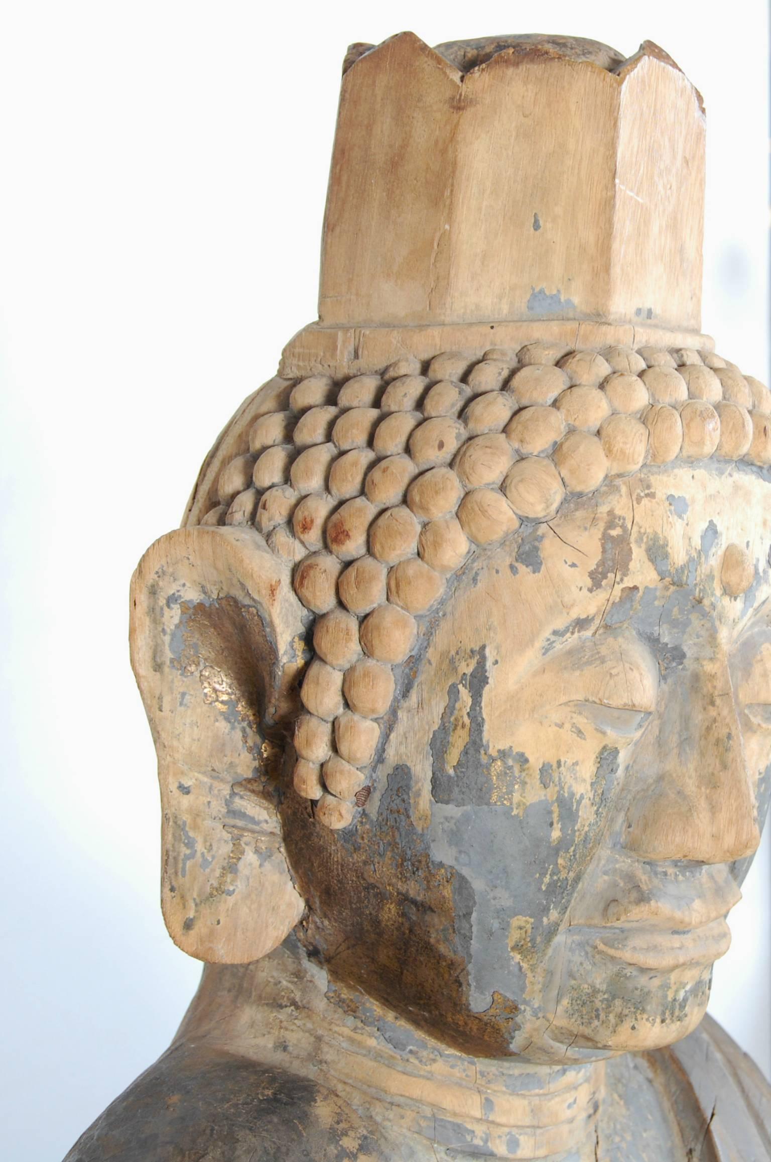 Japanese carved timber statue of seated Buddha, sitting atop a lotus throne. There are traces of the original lacquer and mineral pigments, including some gilding in the ear on the right side.
The position of the hands, with the index finger of the