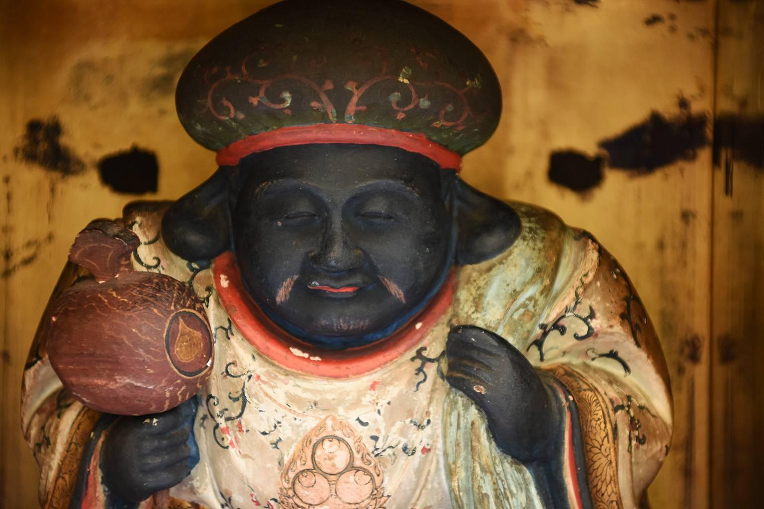 Seltene japanische antike Statue des Daikoku in einem schwarz lackierten Zushi mit vergoldetem Interieur:: Edo-Zeit:: 18. Jahrhundert. 

In der japanischen Mythologie ist Daikoku der Gott des Reichtums und Beschützer der Bauern. In der Regel trägt