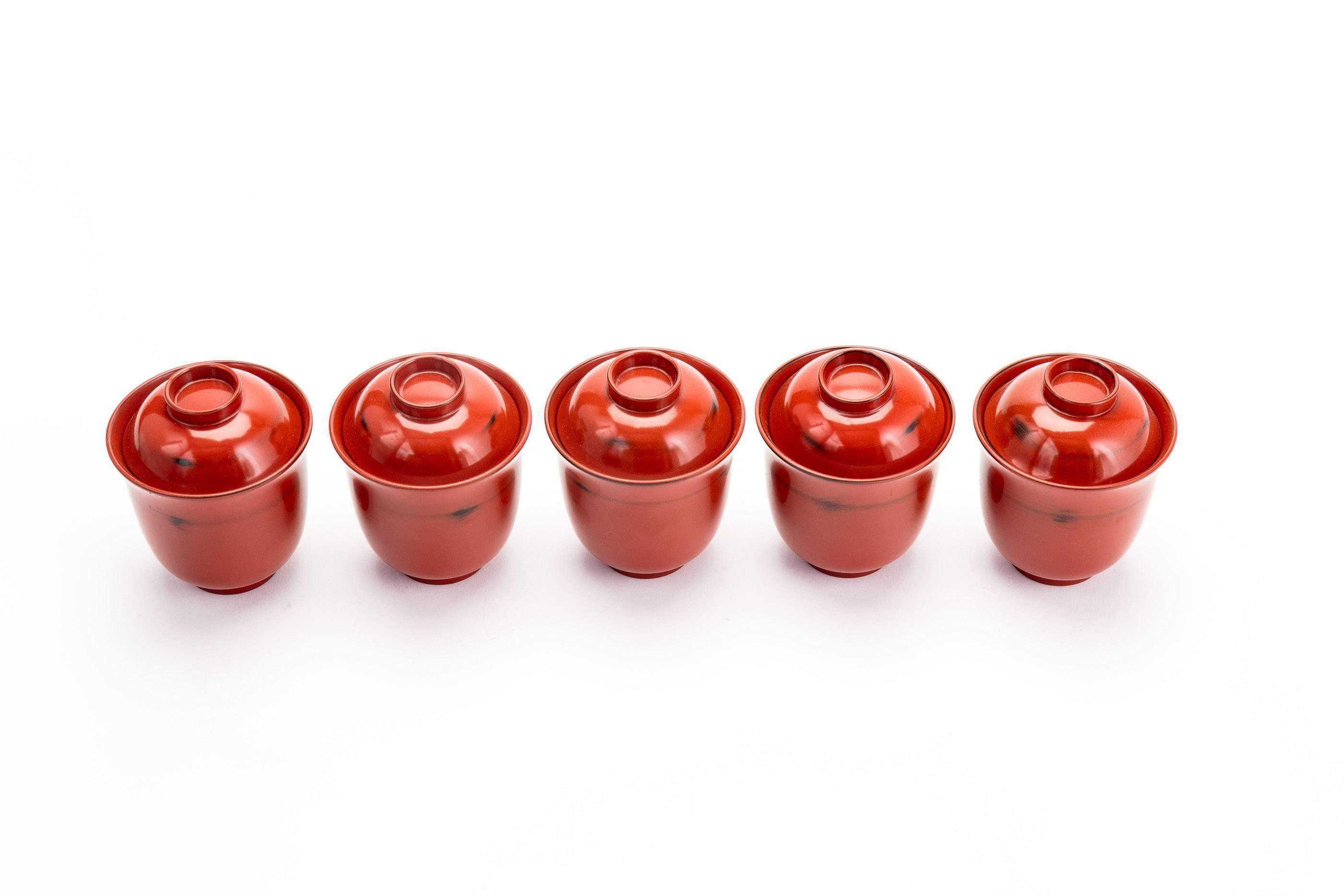 Set of five vintage Japanese Negoro style lacquer rice bowls. 

Negoro lacquer refers to simple red and black lacquerware which was produced in Japan between the 12th and 17th centuries. Negoro pieces are traditionally simple in form, designed