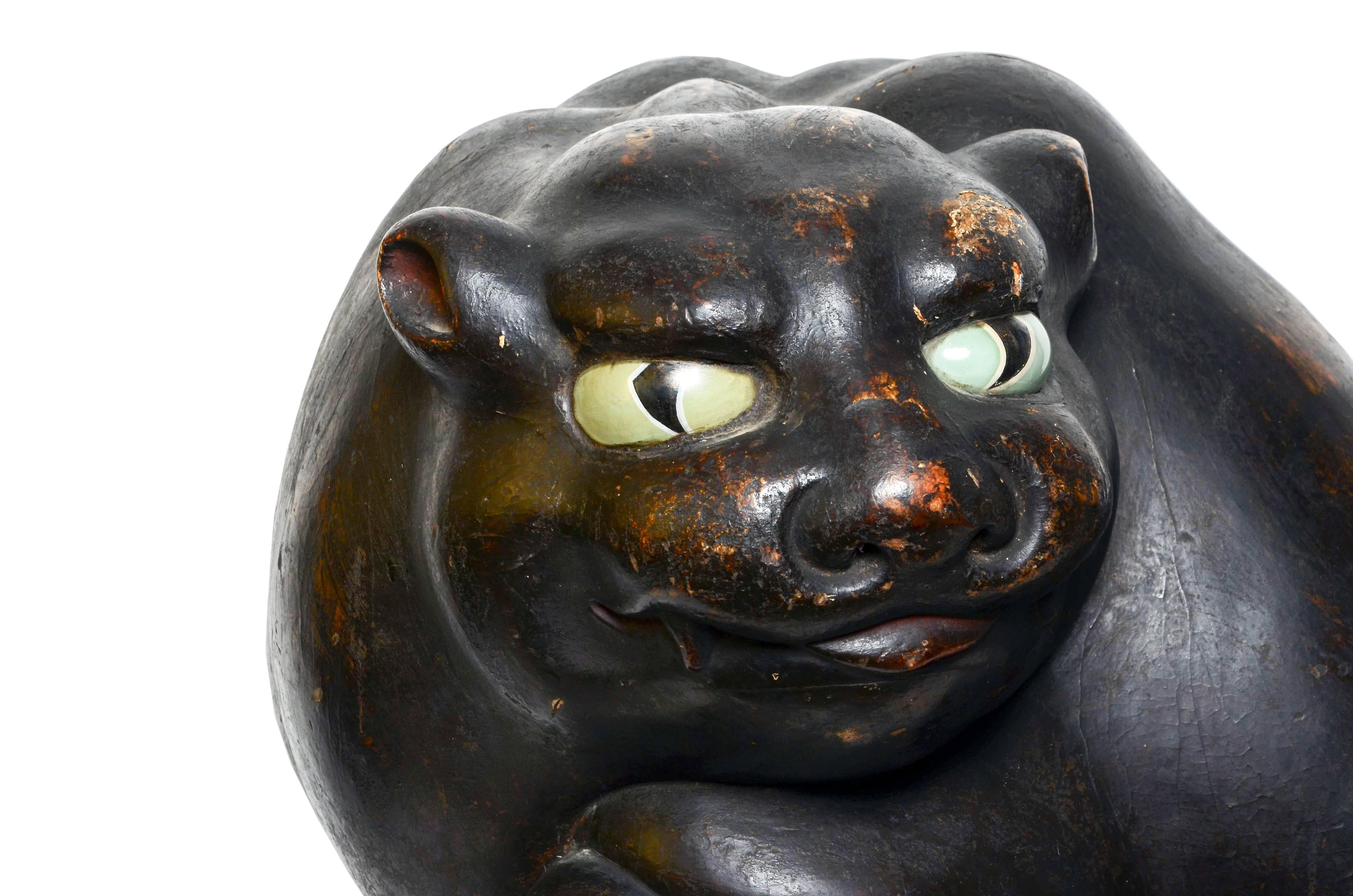 Antique Japanese carved wooden sculpture of a tiger with inset glass eyes, early Edo period 17th century. This original piece has an elegant form and fine patina and was originally purchased in Japan in 1988.

Materials: Carved hinoki (cypress),