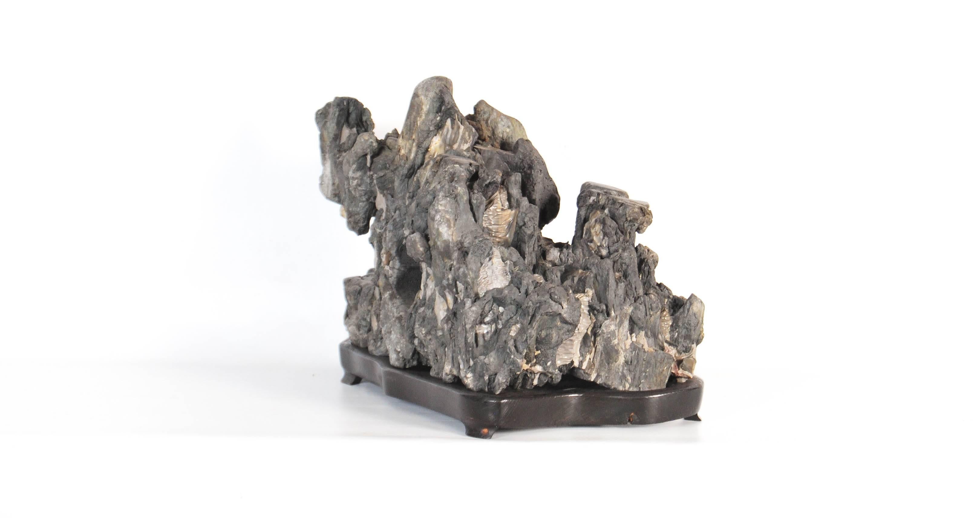 Antique Chinese sculptural 'scholars stone' on a fitted wood Stand, early 20th century.

Dimensions: H 30cm x W 38cm x D 20cm.