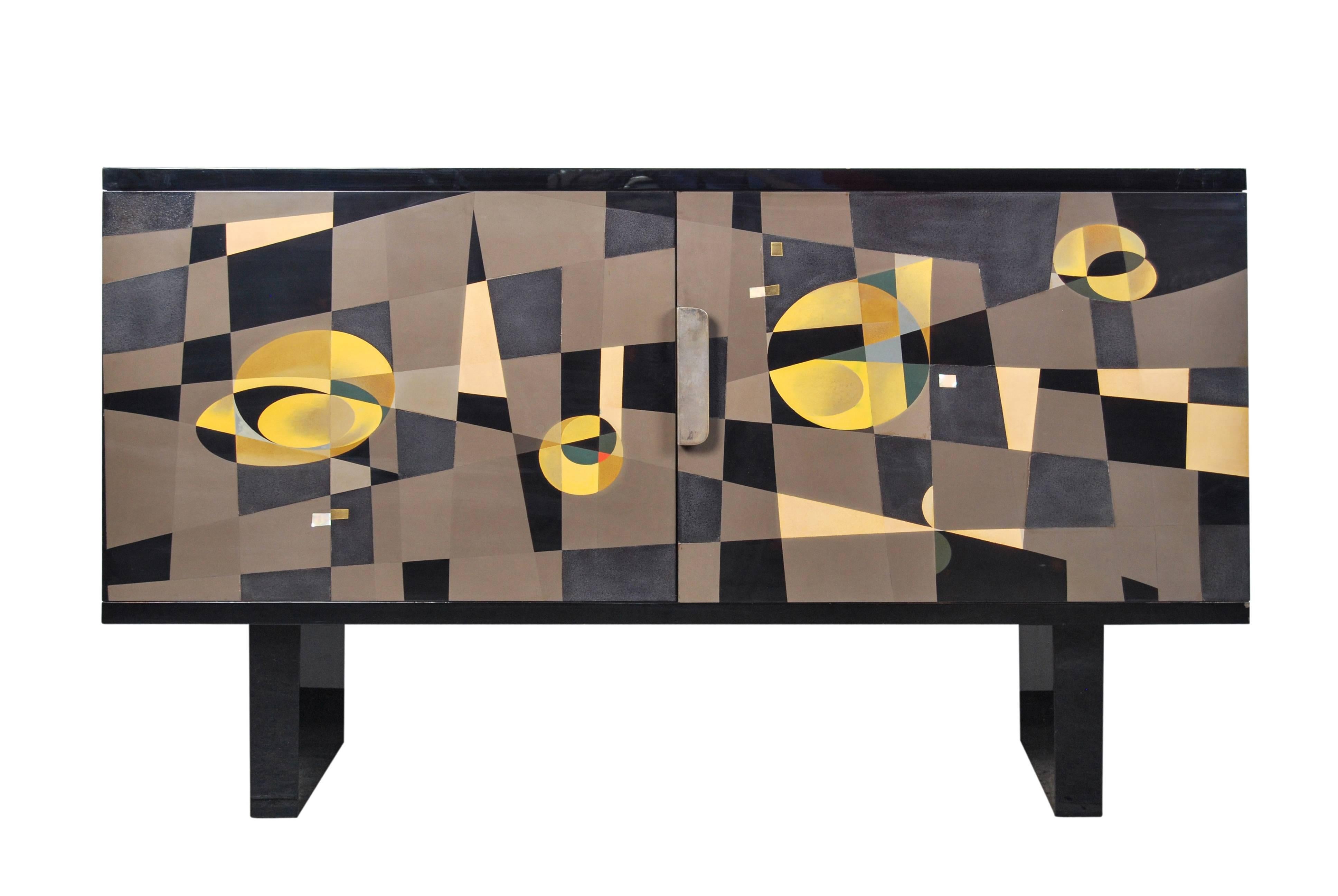 Rare Japanese black lacquered two-door cabinet decorated with a striking geometric pattern rendered in multi colored pigmented lacquer, mother-of-pearl and brass inlays. 

Dimensions: H 74cm x W 125.5cm x D 40cm

Overall good condition aside