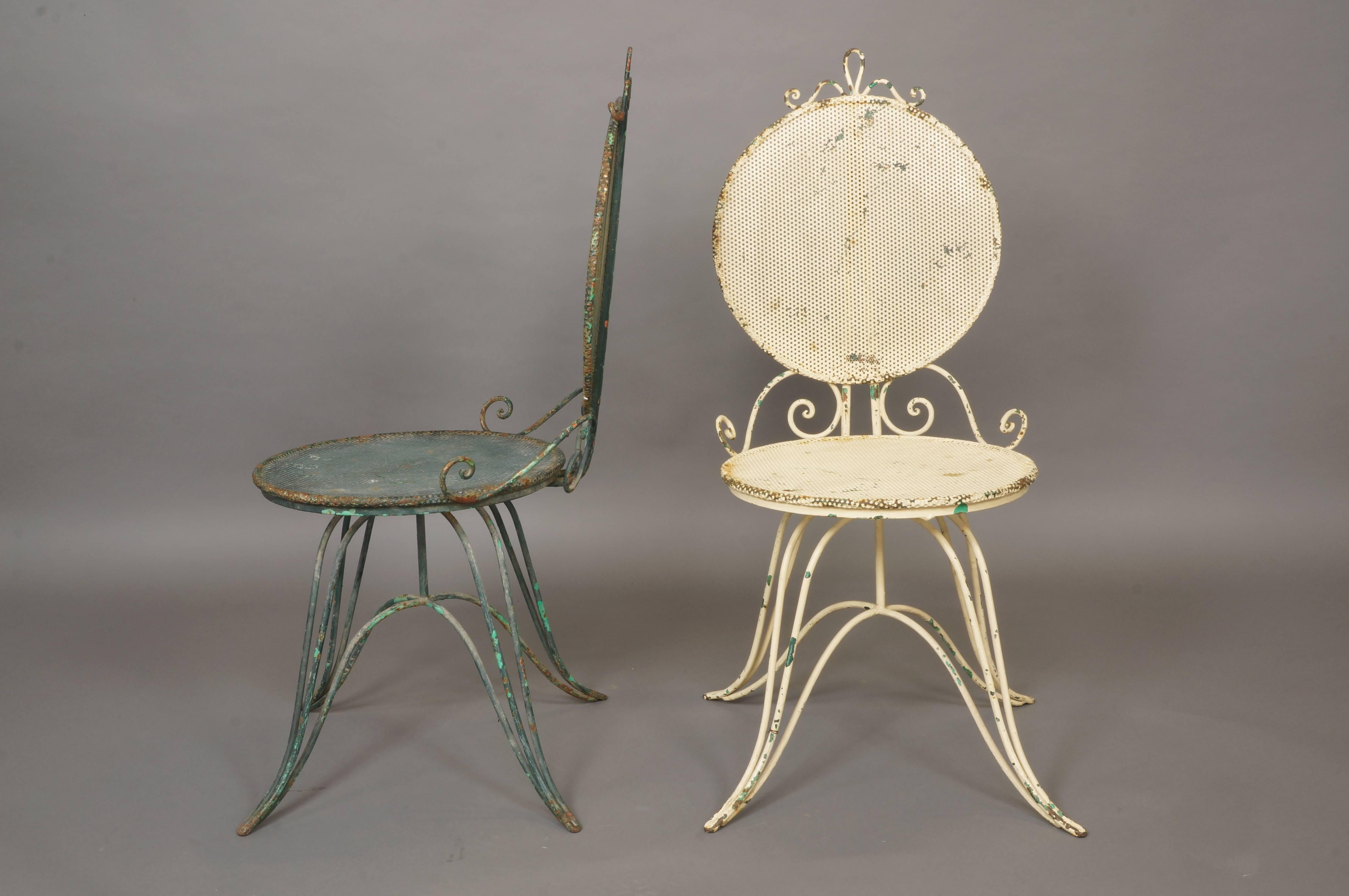Pair of wrought iron Italian painted garden chairs with perforated round mesh backs and seats. Scrolling detail to top and mid section of chairs. Splayed design to foot and base, circa 1950.