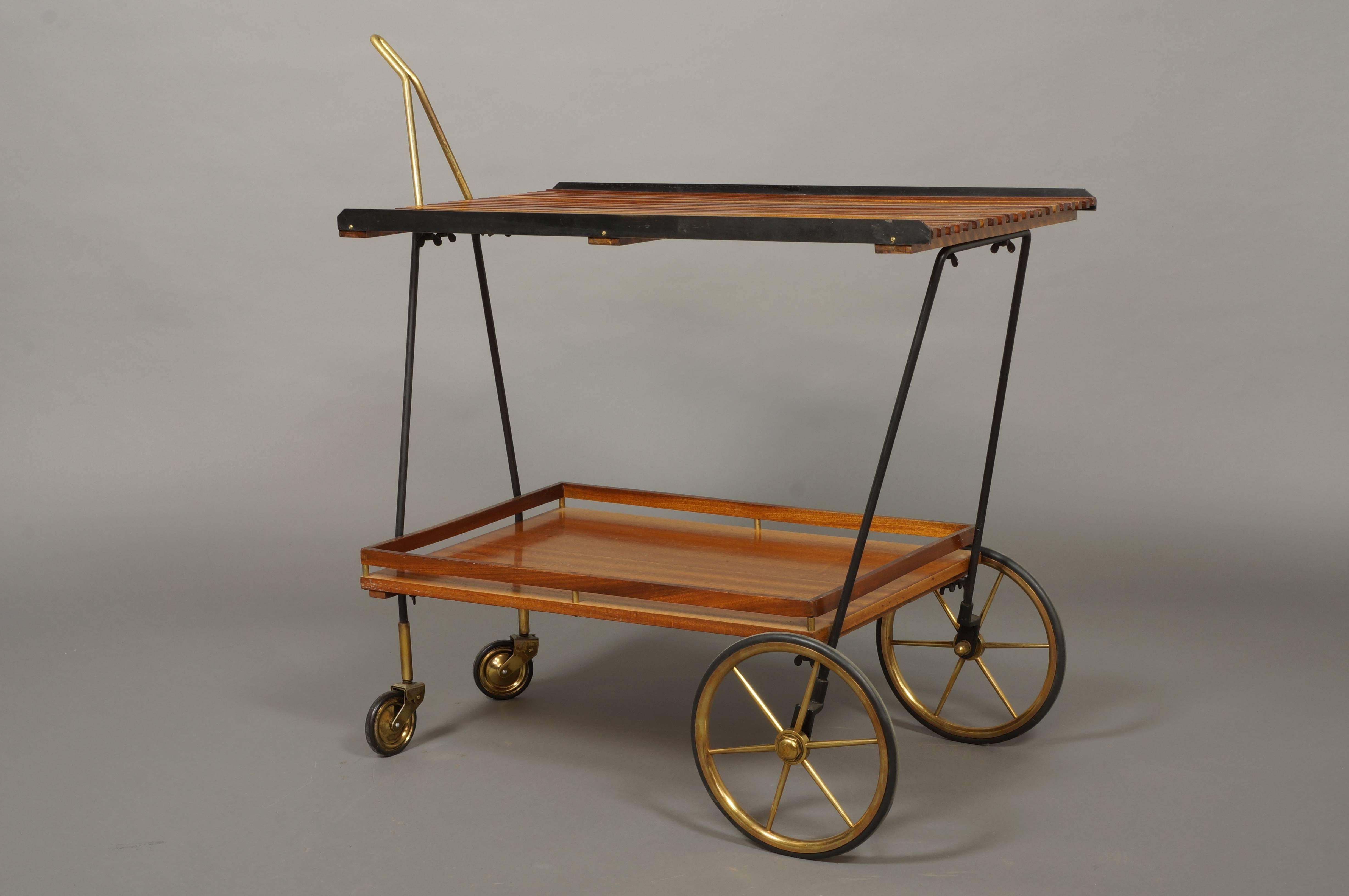 Italian rosewood drinks trolley/bar cart with brass handle and wheels. Top tray has slatted rosewood wood design with blackened steel edge. Lower tray has rosewood and brass gallery, circa 1950.