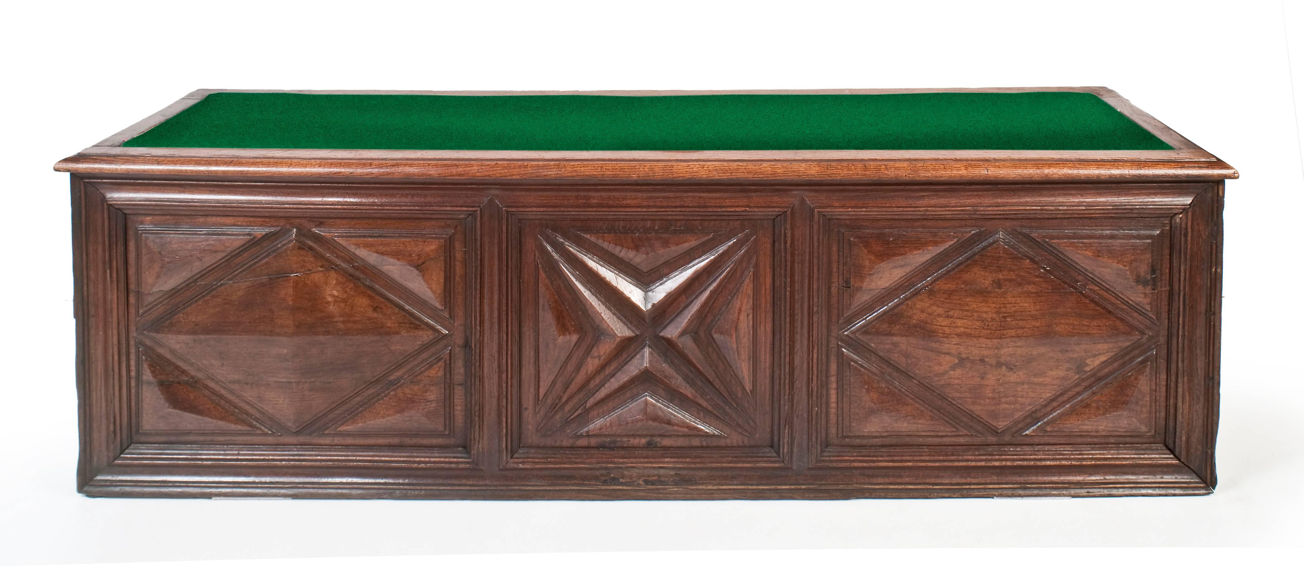 18th century French walnut coffer.
The later hinged tapered, upholstered oak top opening to reveal open storage space above a deep framed rectangular mould, housing three geometric shaped panels. The central a bold ‘X’, flanked by two bold