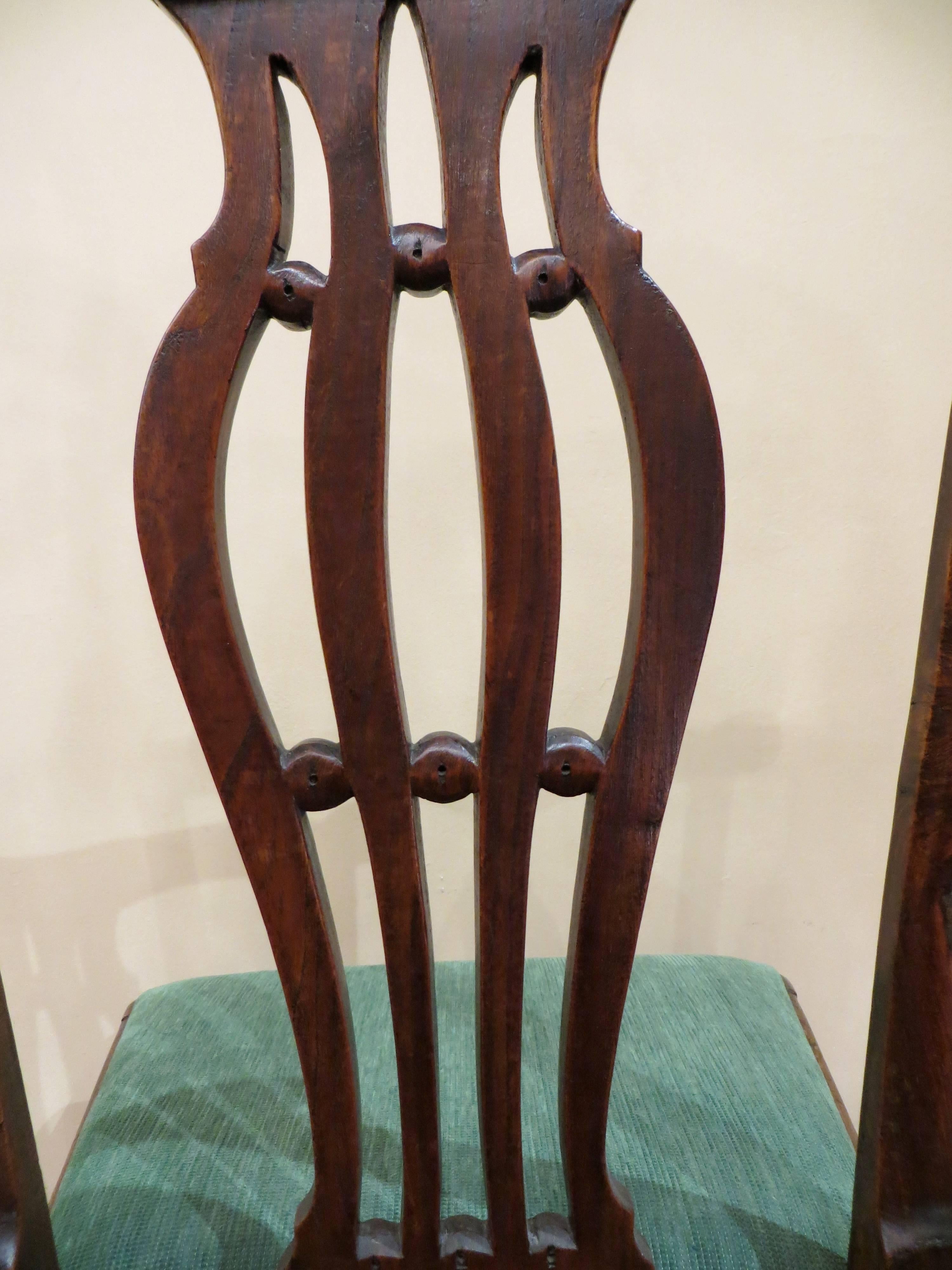 An exceptional late 18th century English elm country Chippendale occasional chair. The well shaped top rail having a long central shaped double scroll, terminating into unusually shaped scrolled ears. Flowing into a fret shaped central splat, joined