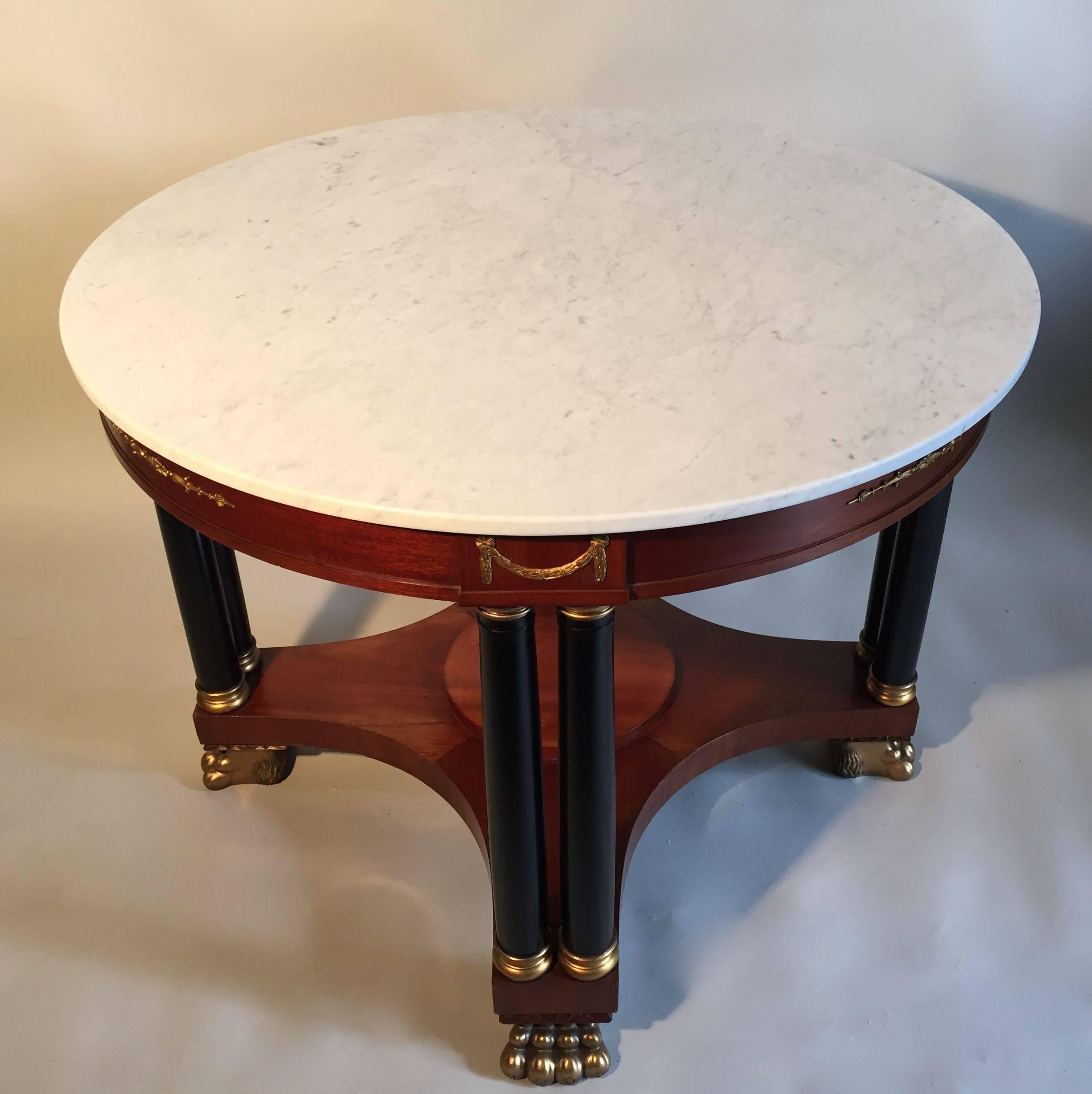 An exceptional mahogany centre table with ormolu mounts and gilded hand-carved lions paw feet. Carrara marble-top is supported by ebonized columns. Original makers label on underside. Made by Axel Beckman, Sweden.