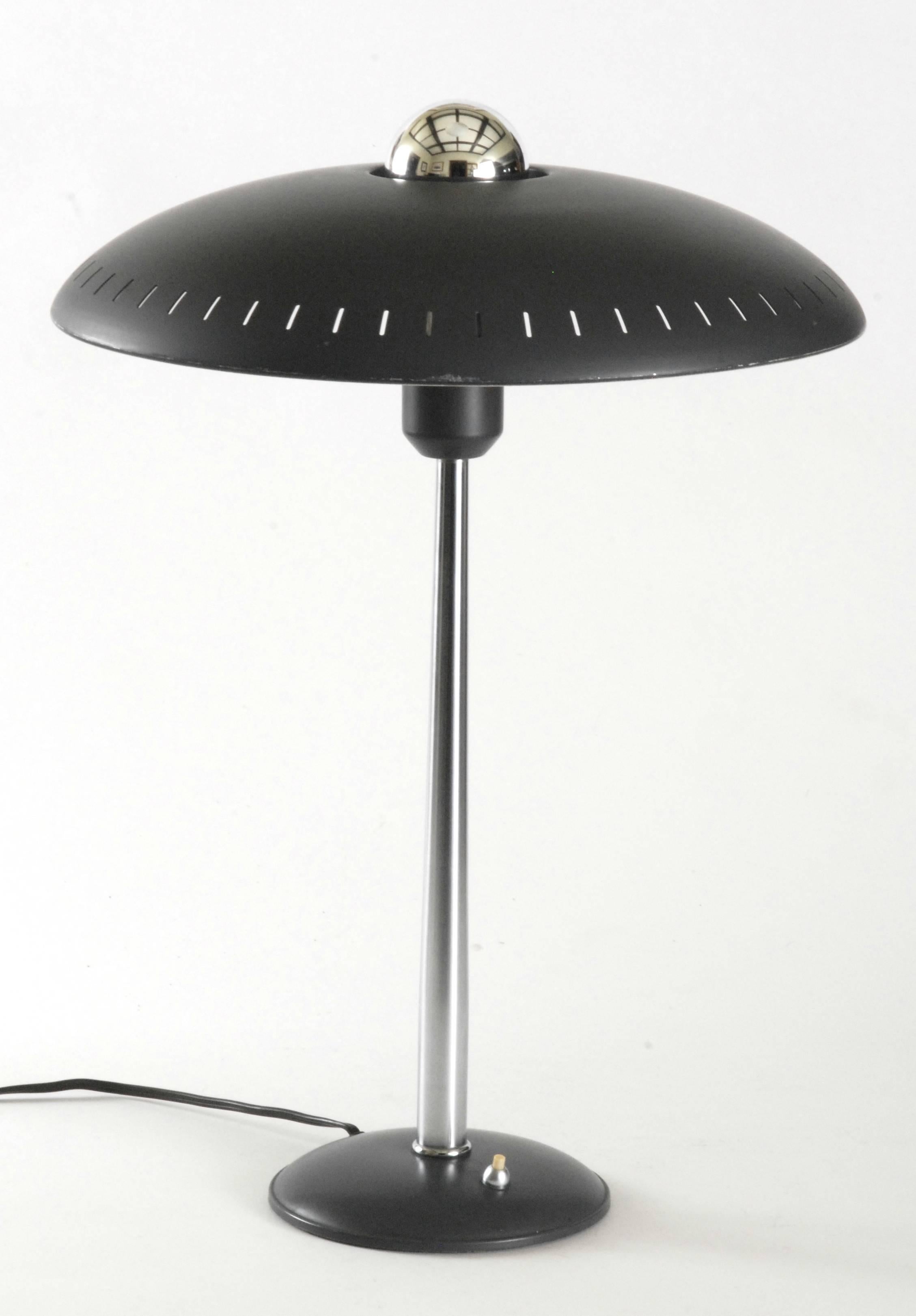 A good 'Timor' model Louis Kalff desk lamp with a pierced edge shade in dark grey and with a chrome stem finishing on a domed circular base.