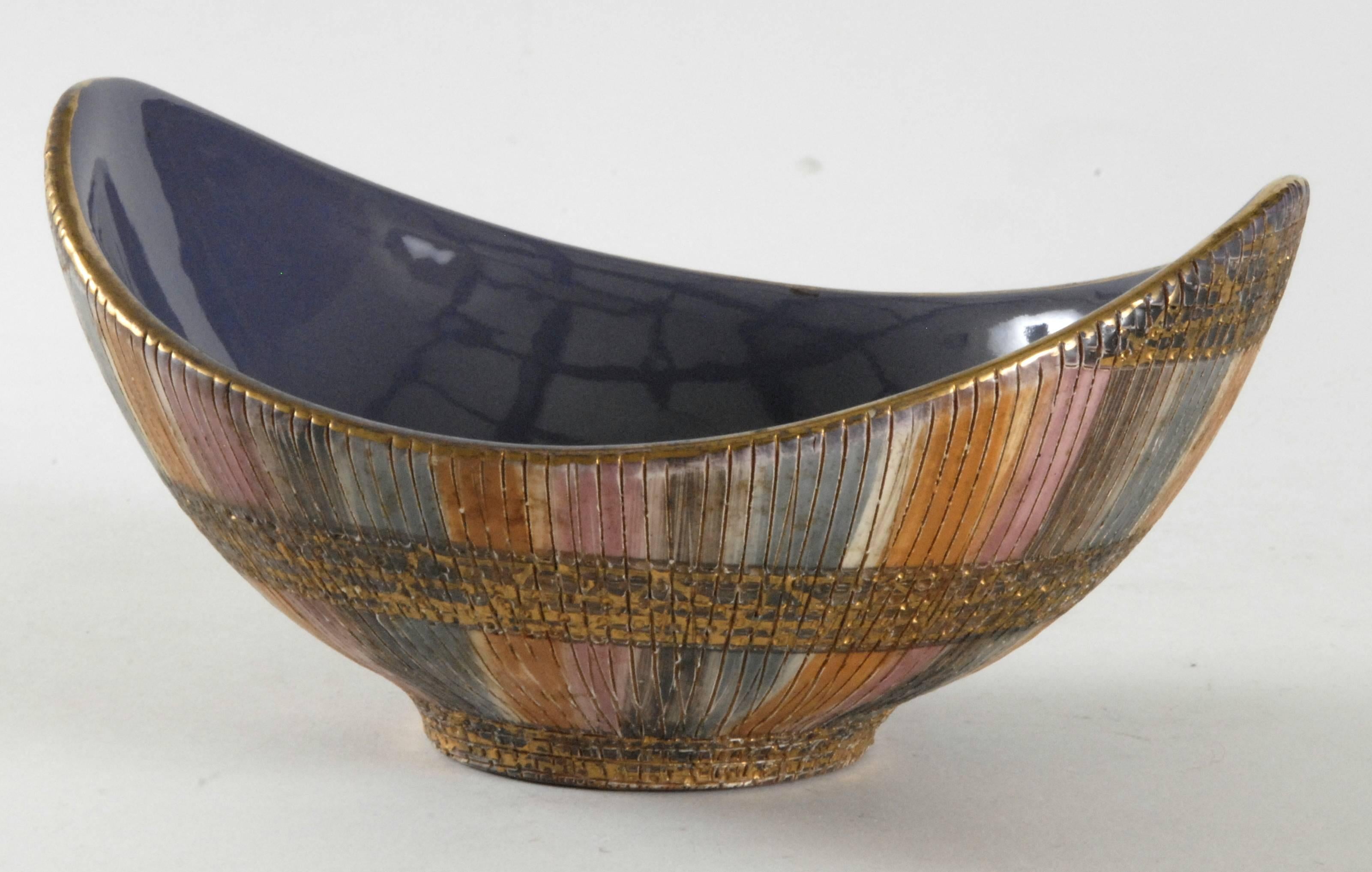 Londi designed the 'Seta' [Silk] pattern circa 1957 and it continued into the 1960s. The exterior decorated with bands of Sgraffito lines and blue, orange, pink and gilt glazes, the interior with a glossy purple glaze, the base painted in black.