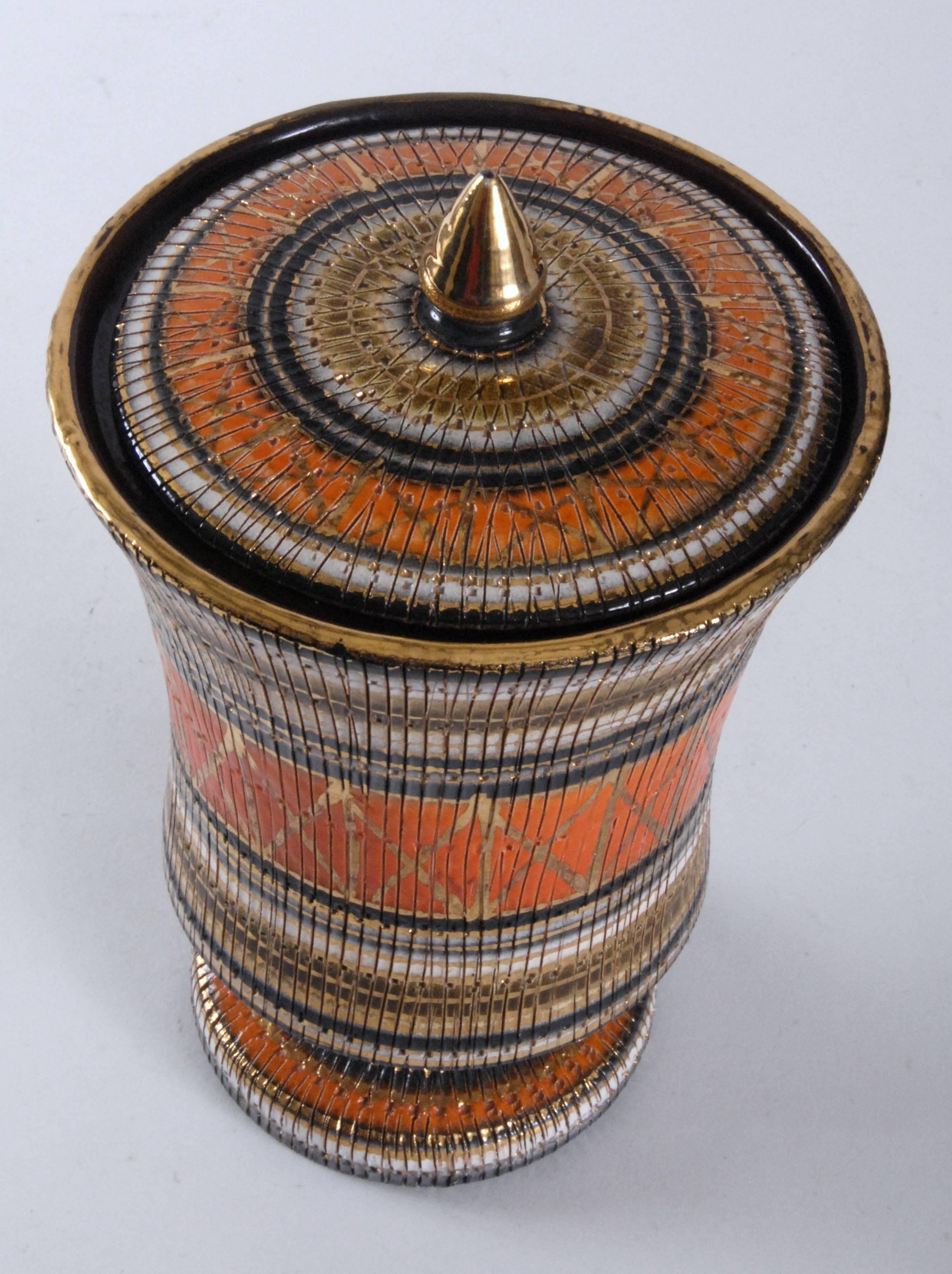 Covered urn in 'Seta' pattern with 'Lobster' version color way. Gilt rims and knop to lid. Signed underneath. Small repair to rim of urn. Interior with a rich brown glaze.