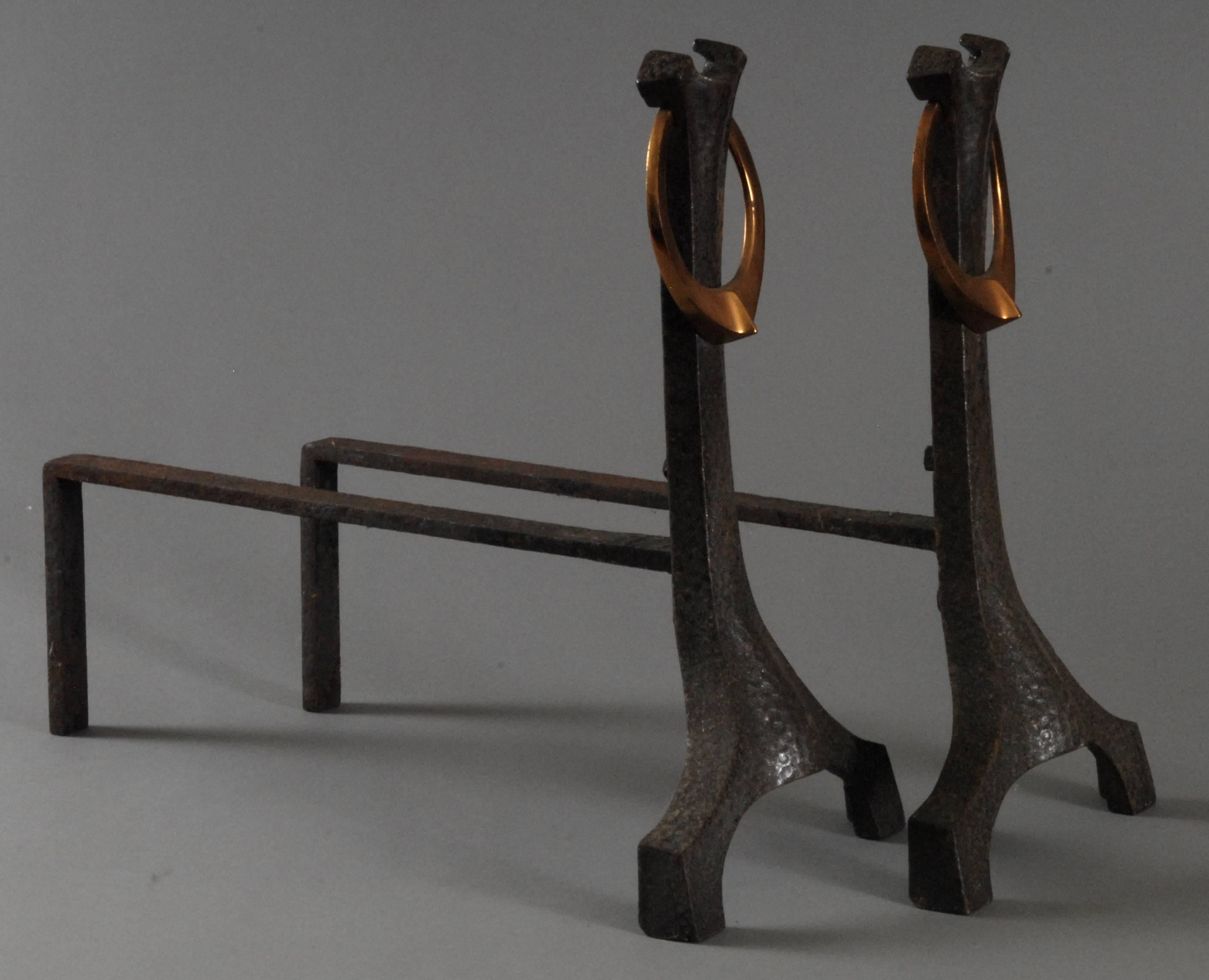 A pair of hammertone finished firedogs with a copper loop affixed to the sweeping shaped curving top. The body sweeping down to a pair of spreading feet and balanced by the protruding rear andiron. Typical Arts & Crafts styling, in immaculate