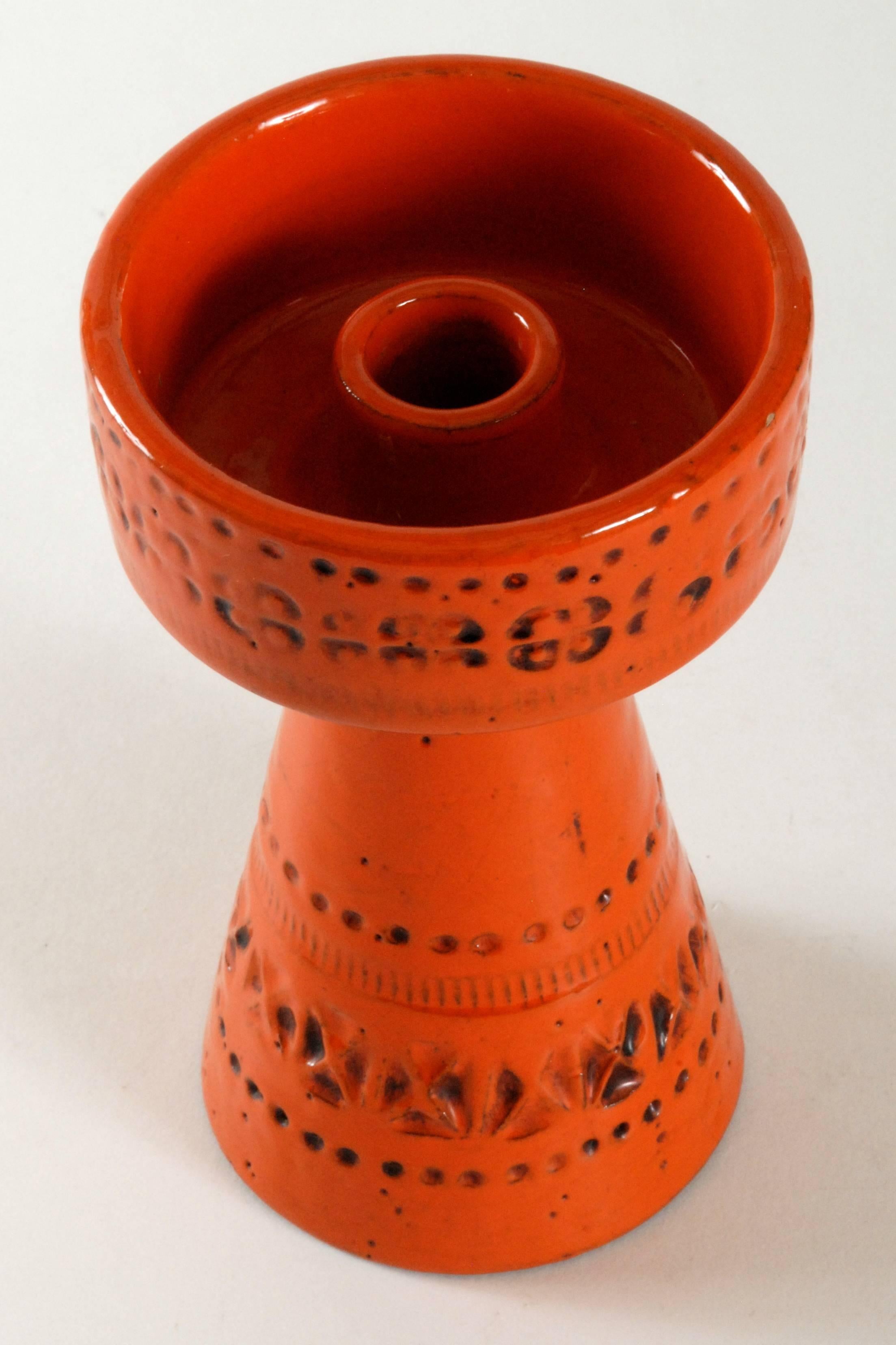 A brilliant orange candleholder in the 'Rimini' pattern designed by Aldo Londi.