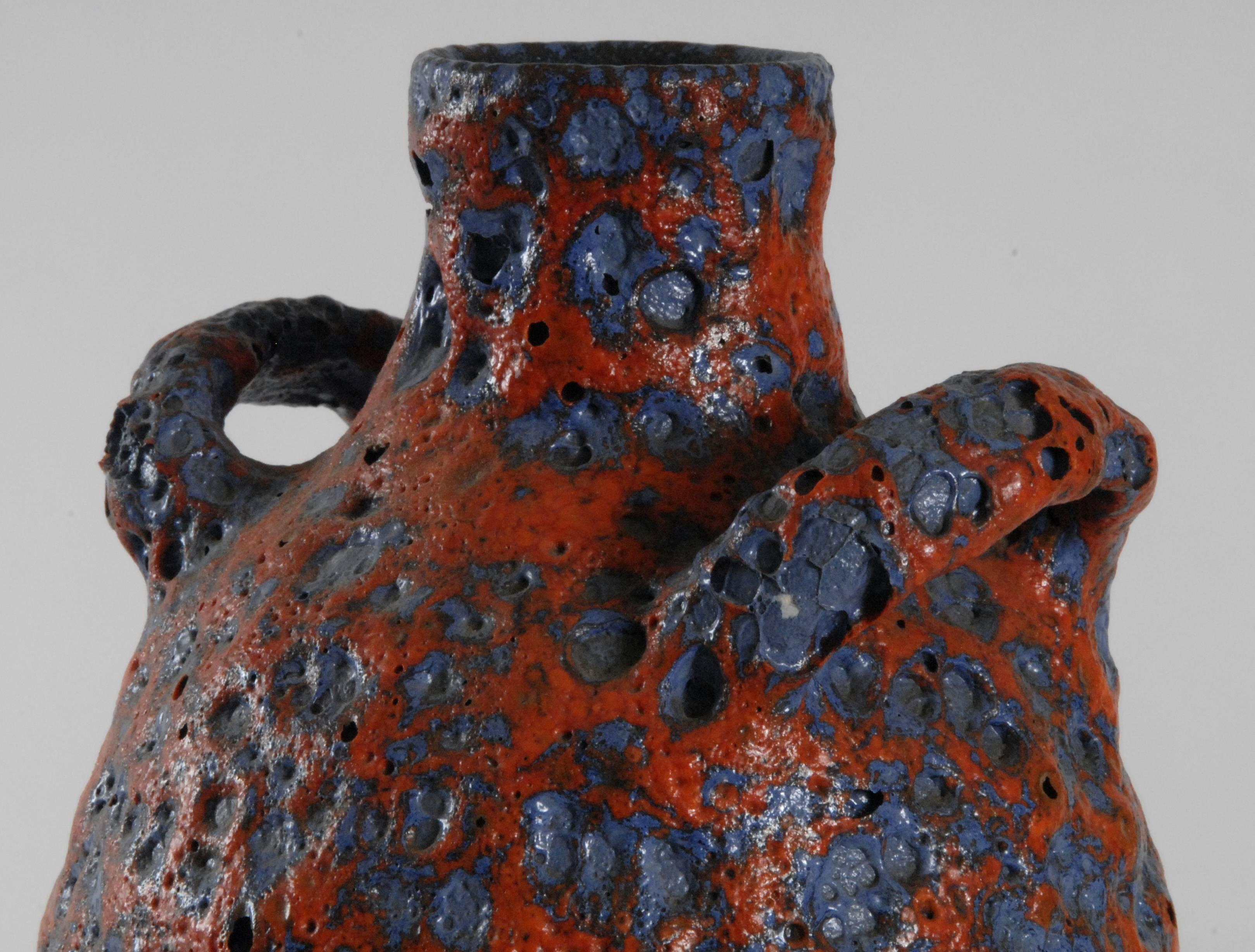An E & S Keramic fat lava urn shaped vase with a red on blue-grey lava glaze. This complex, almost archaic, lava glaze is typical of ES production. The form and glaze are rare. Unmarked.
