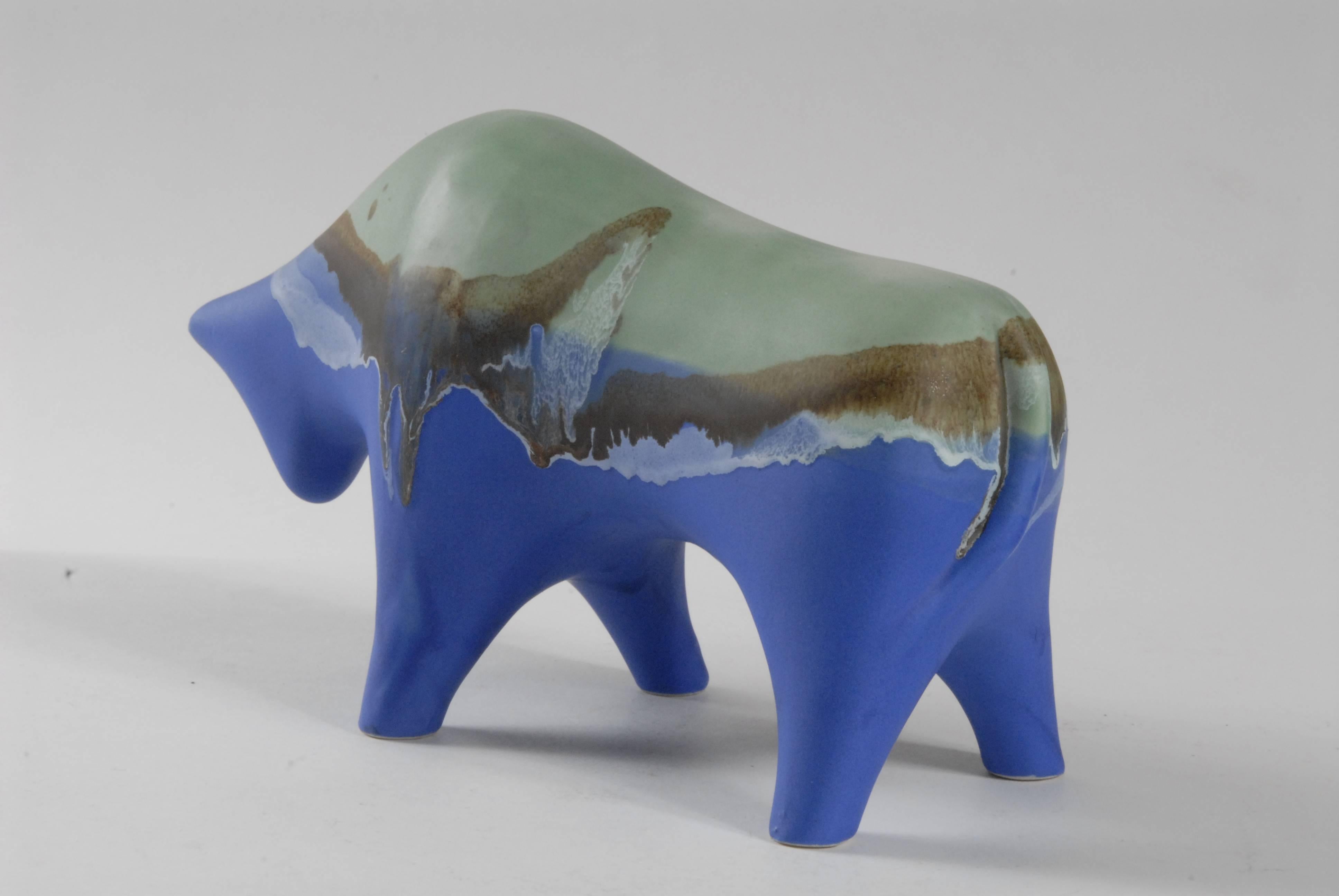 A matt glaze finished bull by Alvino Bagni, Italy, c.1960. Highly stylised bull with head lowered as if about to charge. Coloured with blues, forest green browns and black. Unsigned, but the fine white clay typifies Bagni's use from 1960 onward. 