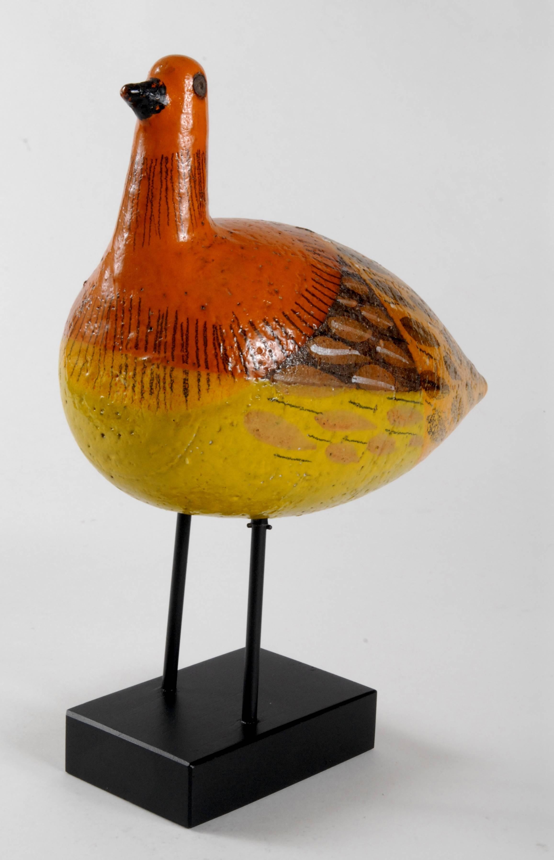 Another inspired Aldo Londi stylized bird from the 1960s, smooth bodied in yellows and oranges and natural brown clay decorated with hand-painted feathers. Timber base in black.