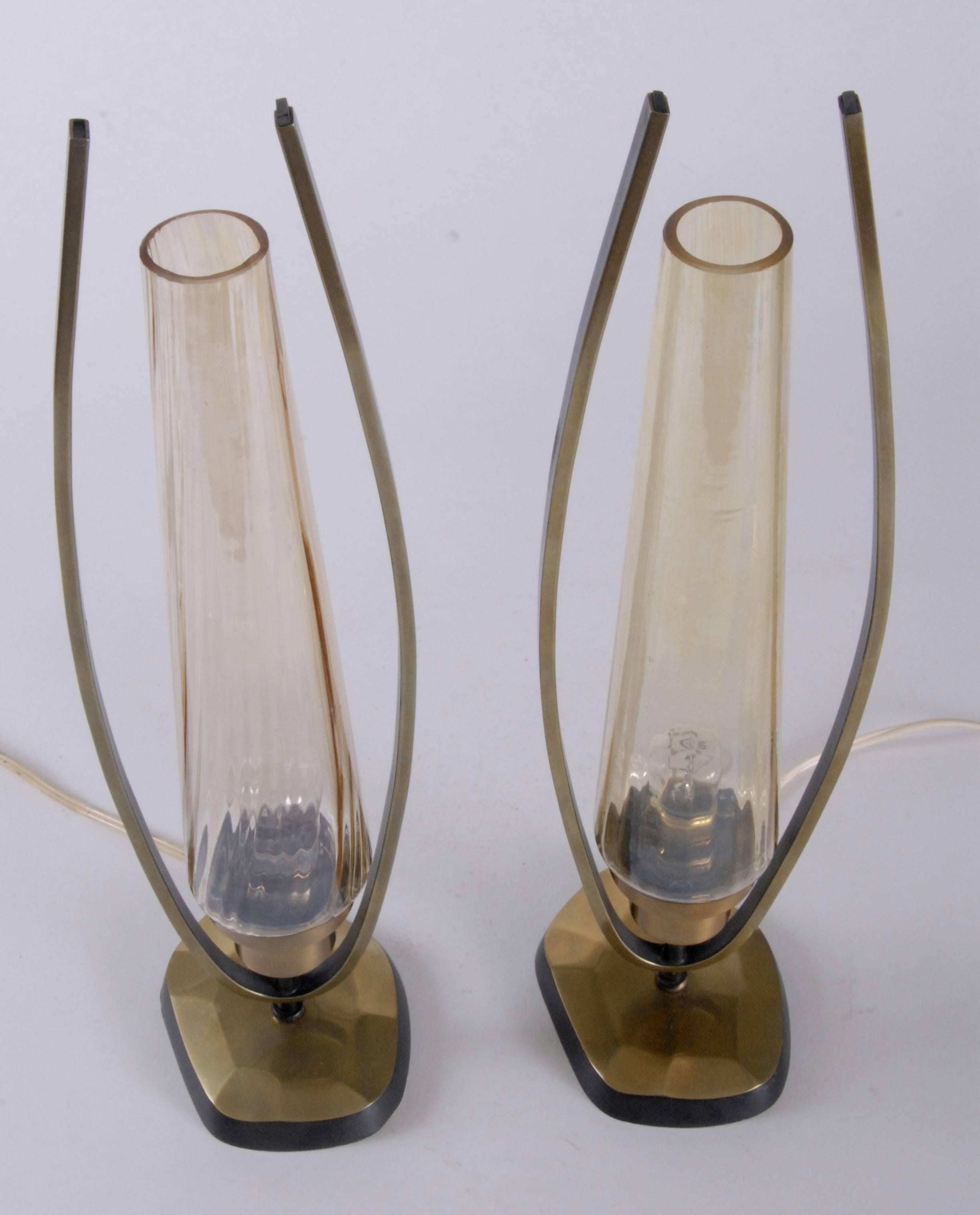 Brass and amber glass pair of table lamps with irregular shaped bases with a black finished edge. The amber glass chimneys are striated and tapered. Lovely condition all round. France, c.1930.