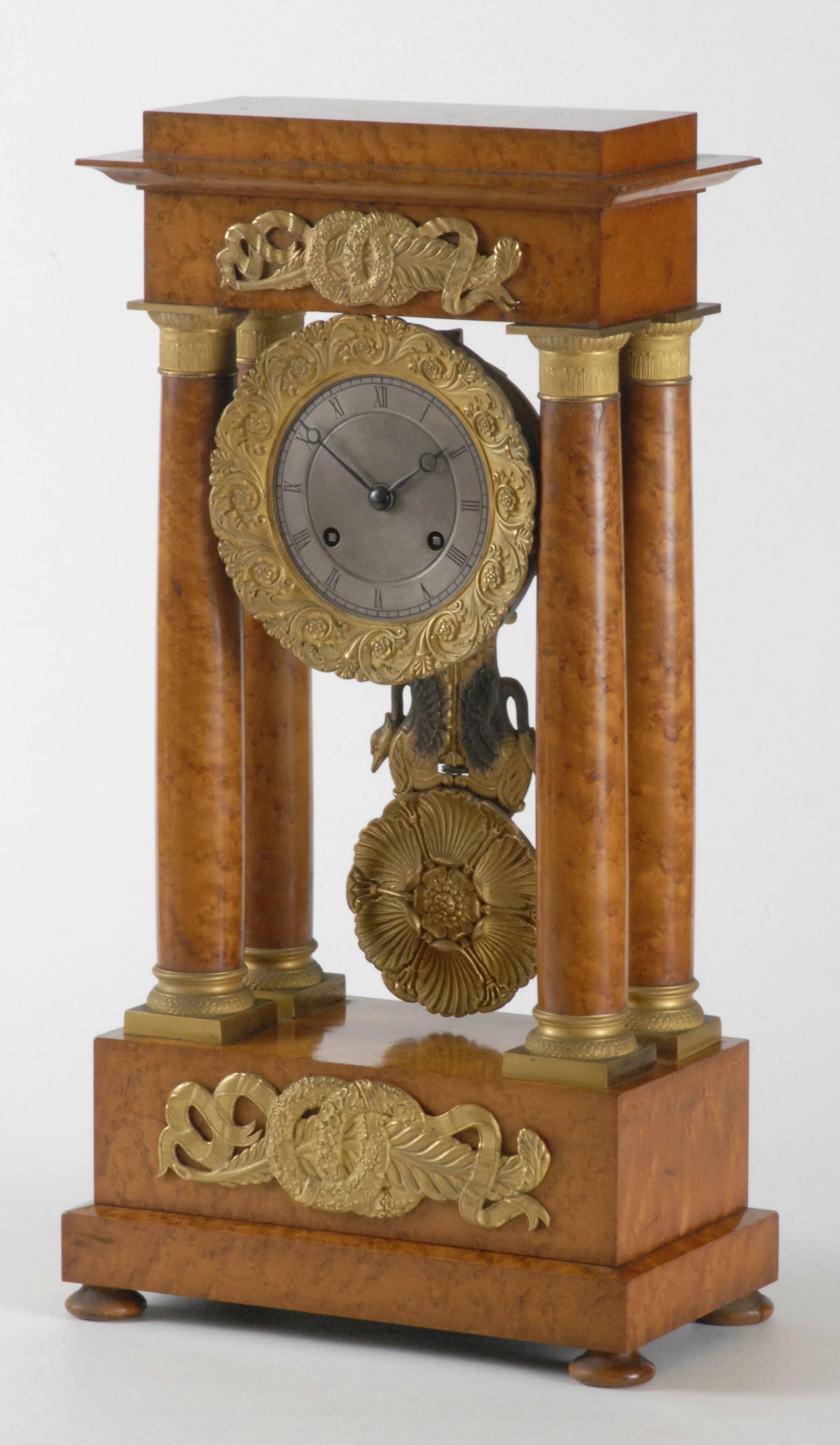 A brilliant French portico clock with ormolu mounts and pendulum mounted with 2 swans with 'blackened' necks and wings.
The timber is gleaming with its original finish. The timber is a highly decorative burr veneer over a solid timber case.
The