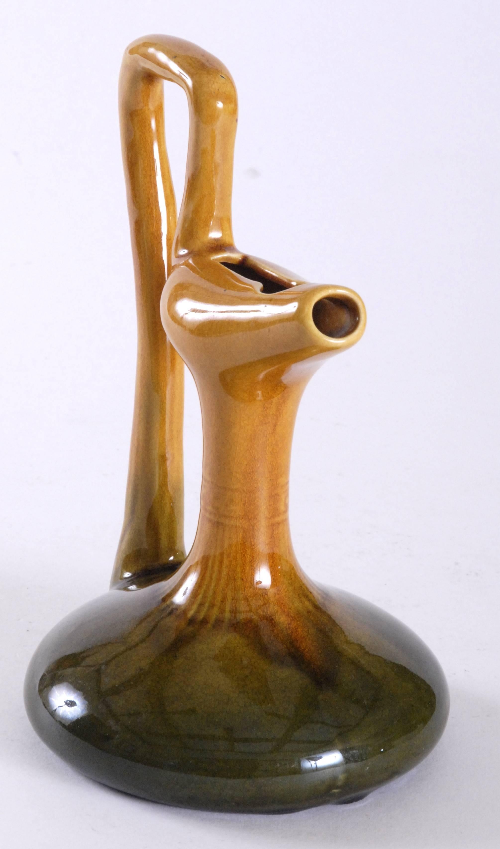 Christopher Dresser designed for the Ault Pottery in the 1890's, taking a lot of inspiration from middle eastern designs, in particular, Persia, of which this an example of a Persian oil ewer. Finely potted with a glorious vibrant glaze of great