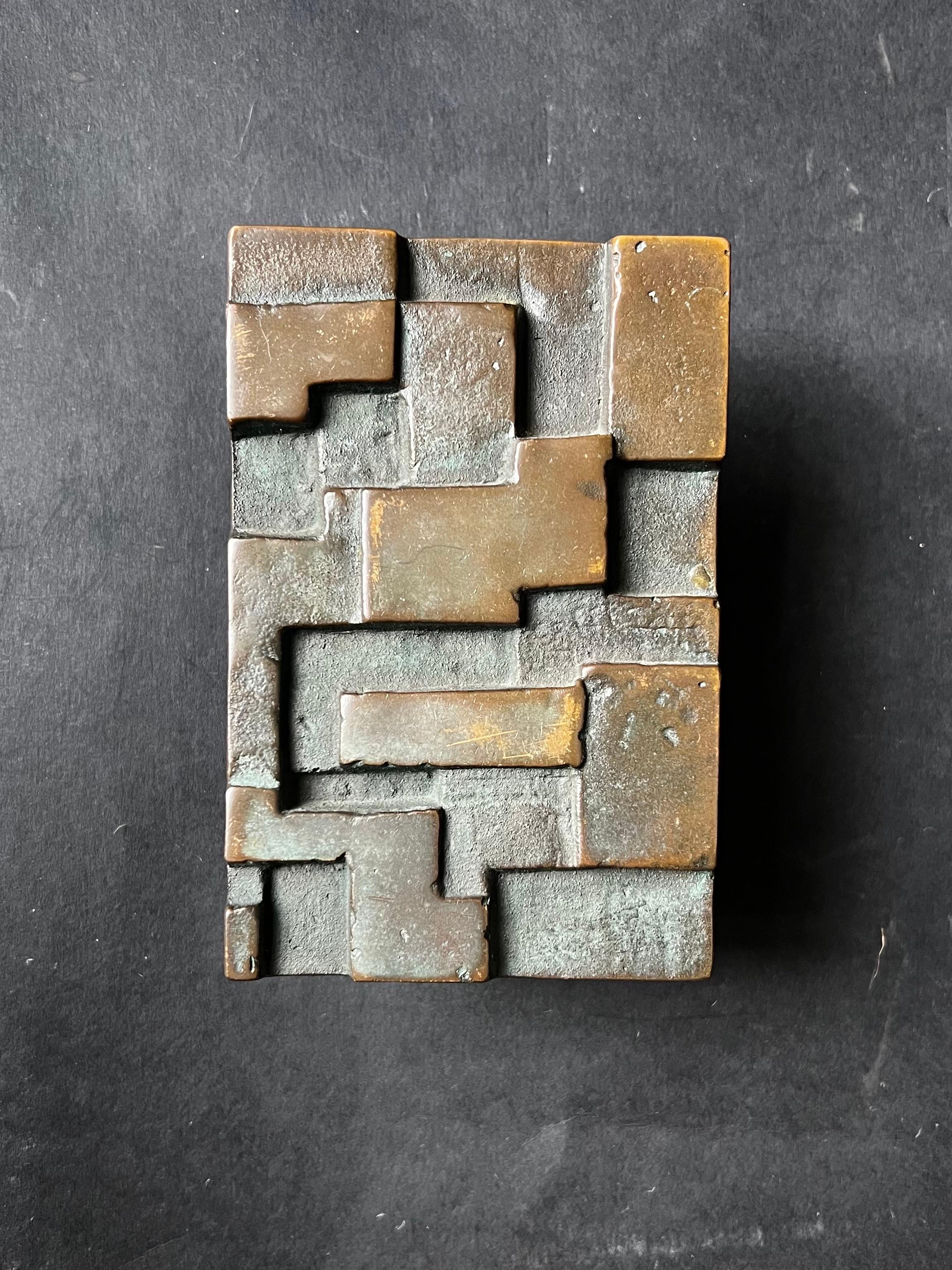 A cast bronze push-pull door handle with raised geometric design. Mid to late 20th century, found in Germany.

A nice heavy piece with lots of patina. Typical signs of wear include scratches from handling and changing tones from dark brown to deep