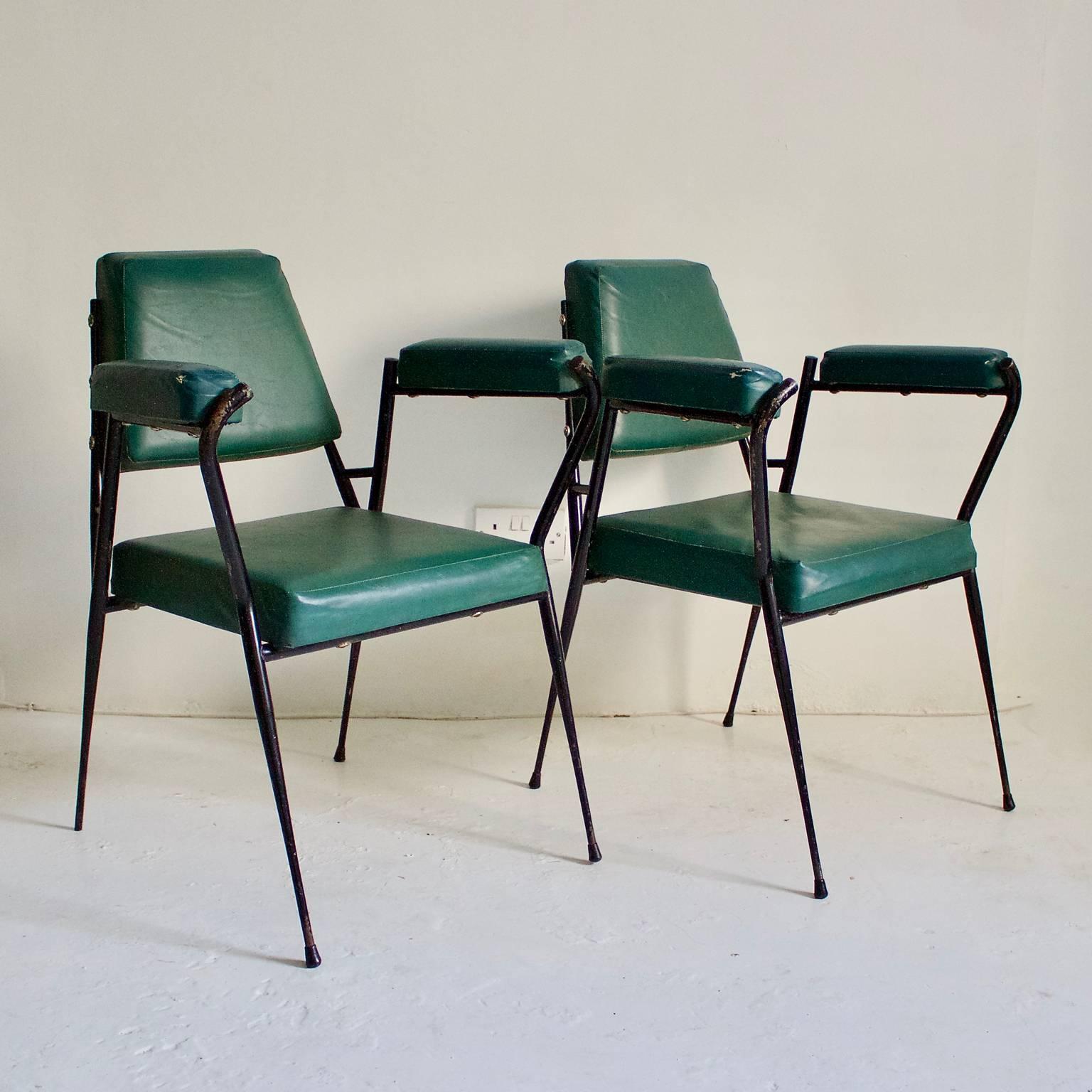 A pair of simple Italian office chairs or occasional chairs, manufactured by Fratelli Ferrari & Co., 1950s.

The chairs have black metal frames with fine pointed legs, and green upholstered panels and armrests finished in original fabric. The chairs