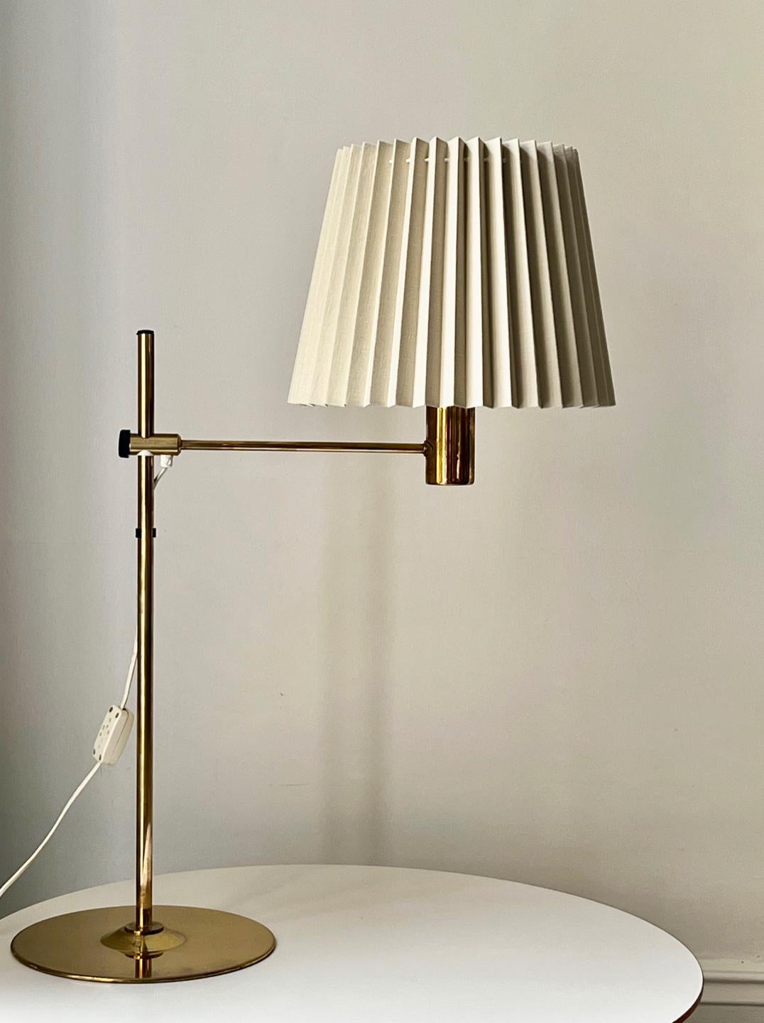 A good sized table lamp in brass by Hans Agne Jakobsson, and made by his company in Markaryd, Sweden, mid-20th century. Labelled to the base.

A simple design with a height-adjustable brass arm and a good weighted base. The brass is in good vintage