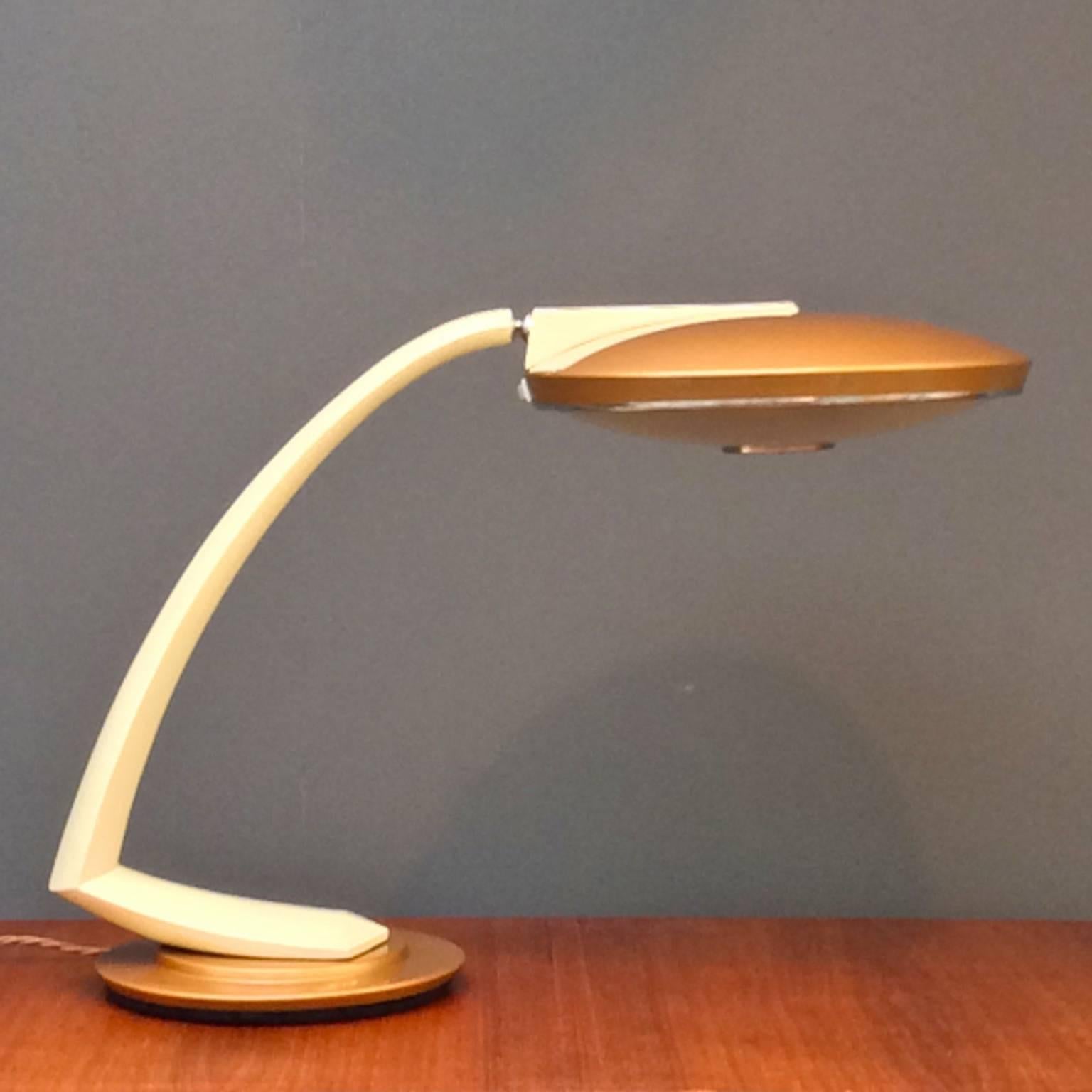 Stylish and architectural desk lamp by Fase of Madrid, Spain, 1960s.

The lamp has a metal body finished in shades of cream and tan, with flying saucer style shade and original glass diffuser. The position of the shade is adjustable through the