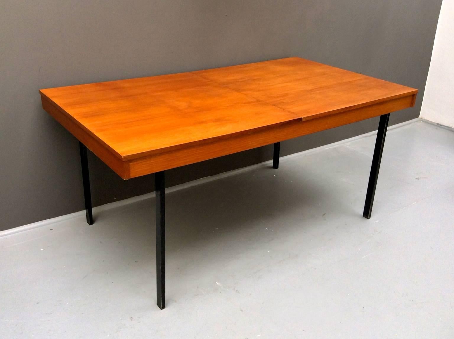 Modernist dining table by the French designer and architect Pierre Guariche for the Belgian manufacturer, Meurop, 1950s.

The simple and elegant design is finished in teak with rectangular steel legs finished in black lacquer. The tabletop divides