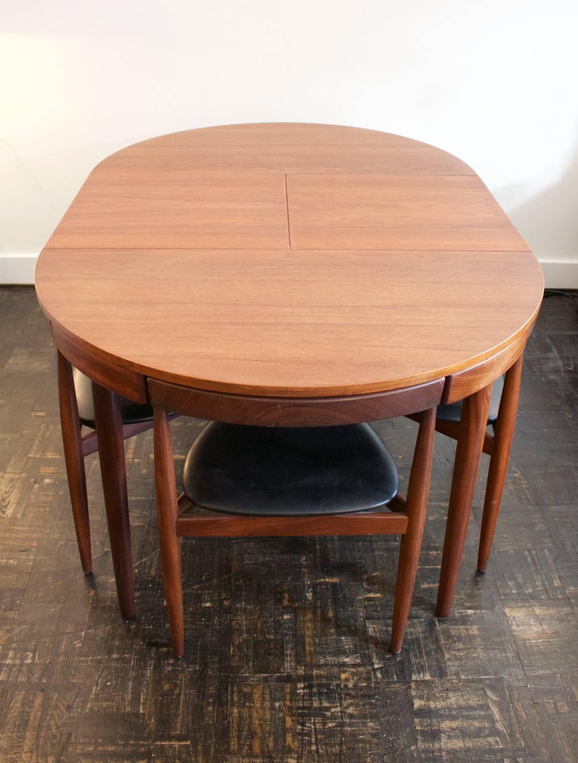 Dining set by Hans Olsen for Frem Rojle of Denmark comprising extending dining table and four three-legged chairs.

A very nice combination of stylish and practical design. The circular teak table top extends through a hidden butterfly leaf. The