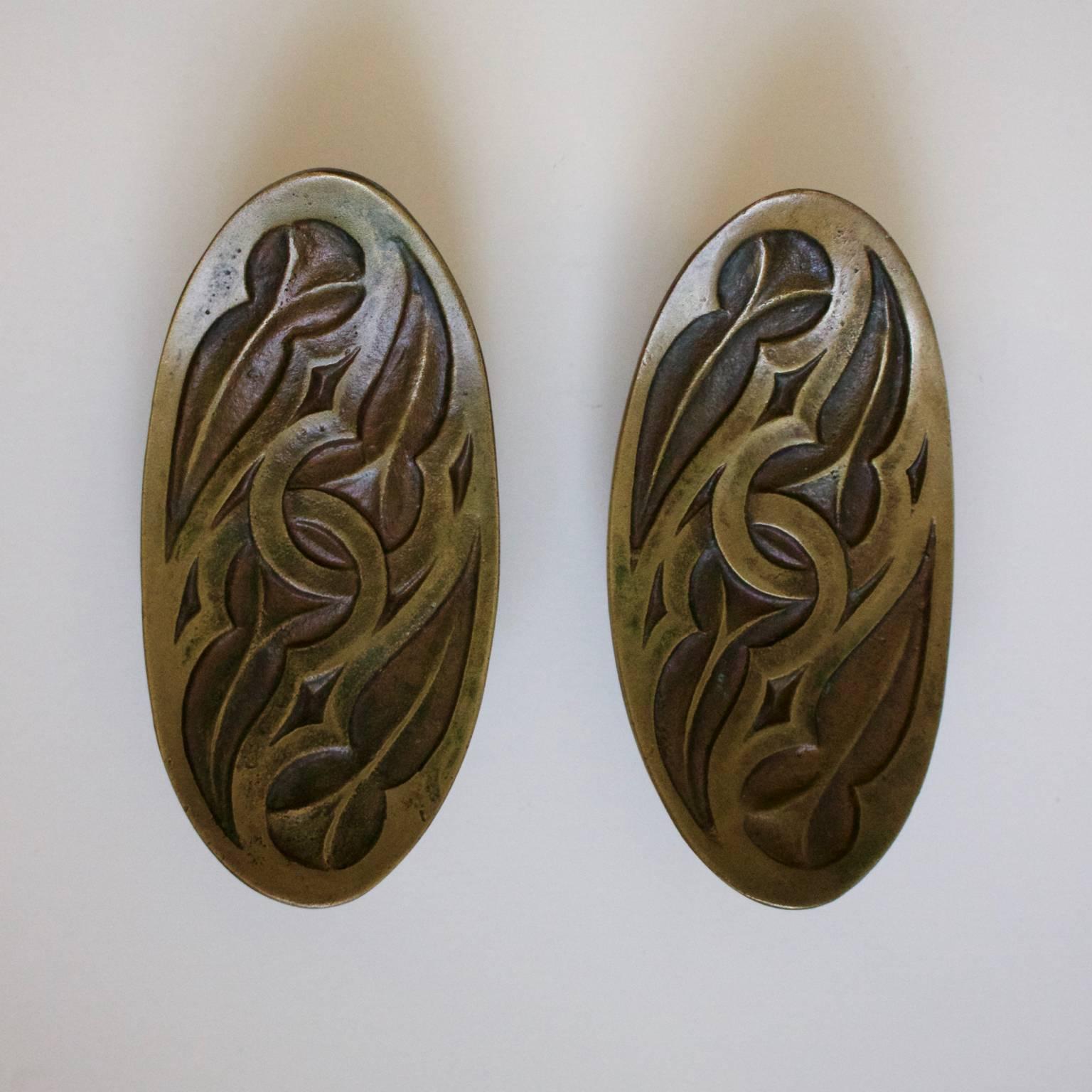 Set of cast bronze door handles in an Art Nouveau or Celtic style. Italian, probably mid-20th century.

Nicely made handles, in very good condition with age-related patina; possibly unused as a rubber spacer which stops the discs rattling around is
