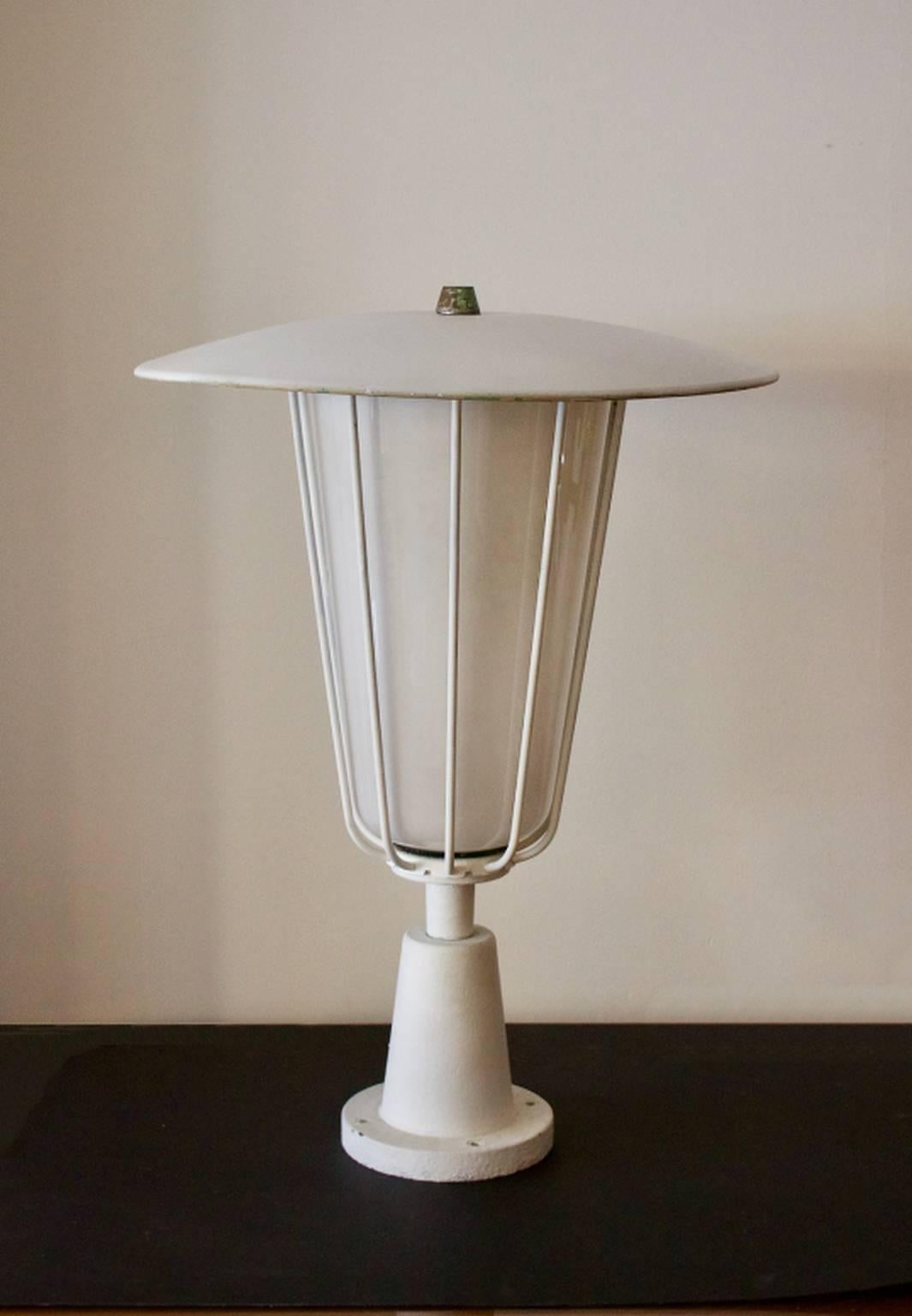 A large garden lantern with white opaline glass shade and metal frame. Manufactured by Bega, Germany, 1950s.

A striking piece in good overall condition. The metal frame shows signs of wear in line with age: the surface has been overpainted in the