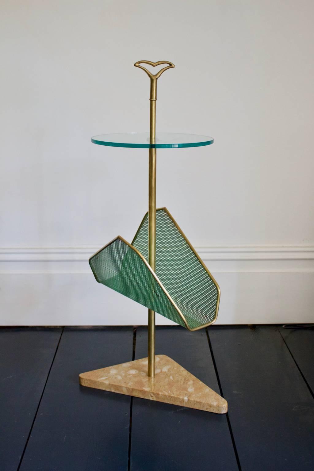 A stylish side table with magazine rack, very much in the style of Cesare Lacca, Italy, 1950s.

The piece comprises a brass stem and handle with glass tabletop, perforated metal magazine rack and pink marble base.

The piece is in good original