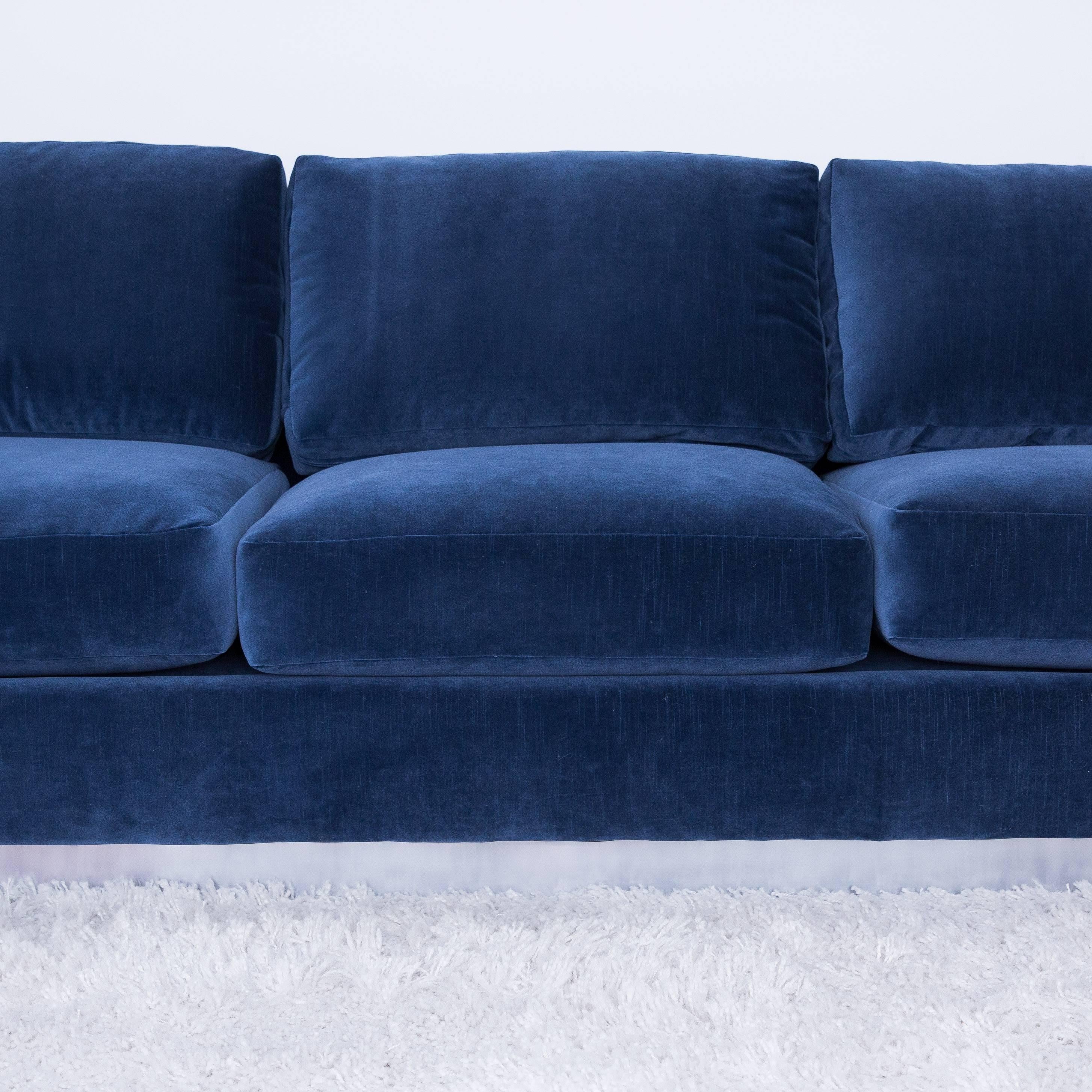 Designed by Cy Mann exclusively for his Manhattan design store in the 1970s this 7' sleek low sofa sits on a brushed aluminum faced pedestal. It's been newly reupholstered in grey blue velvet fabric.