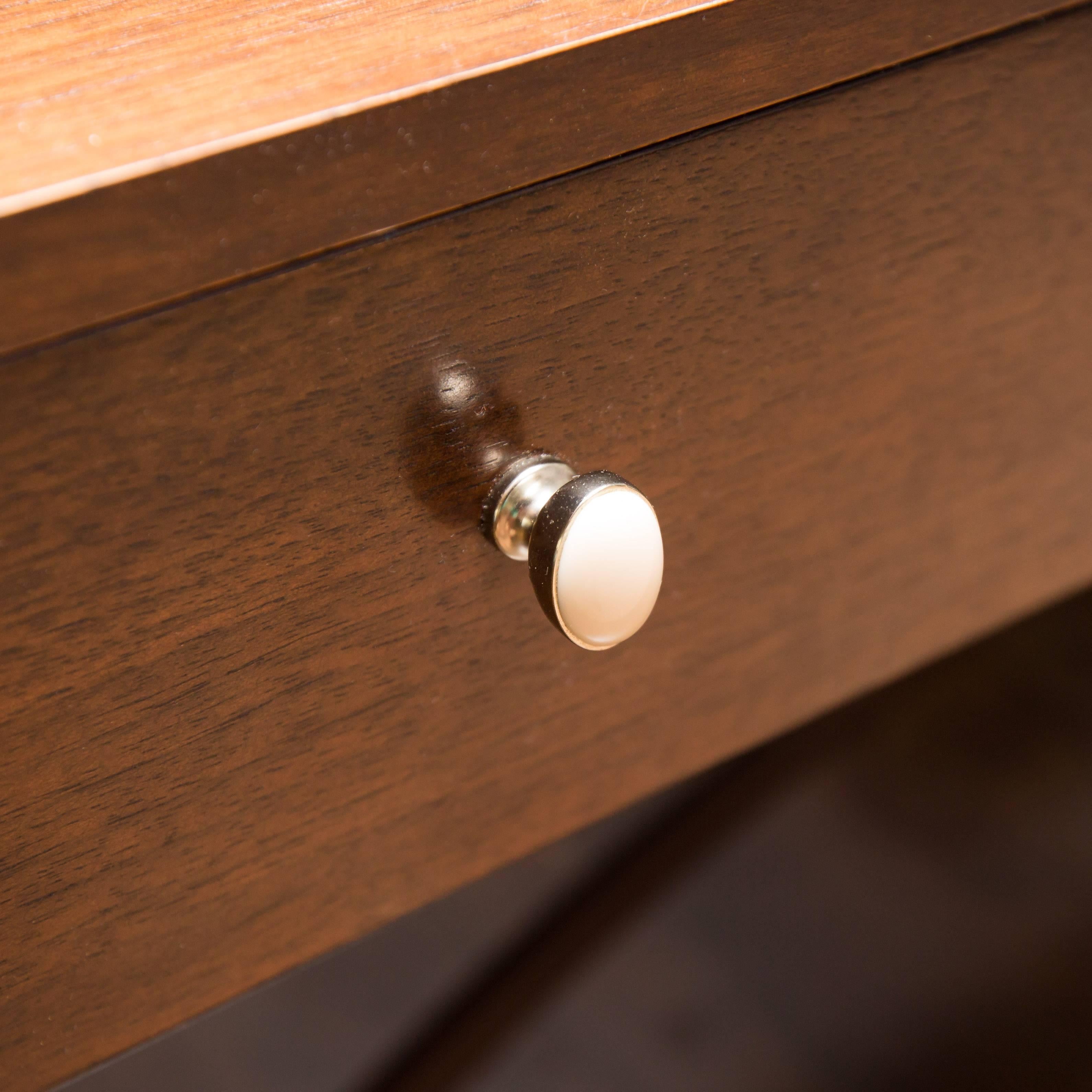 This is a classically shaped three-drawer walnut writing desk designed by Barbara Barry for Henredon. Nickel-plated leg caps and ivory like drawer pulls add to this iconic, out of production piece.