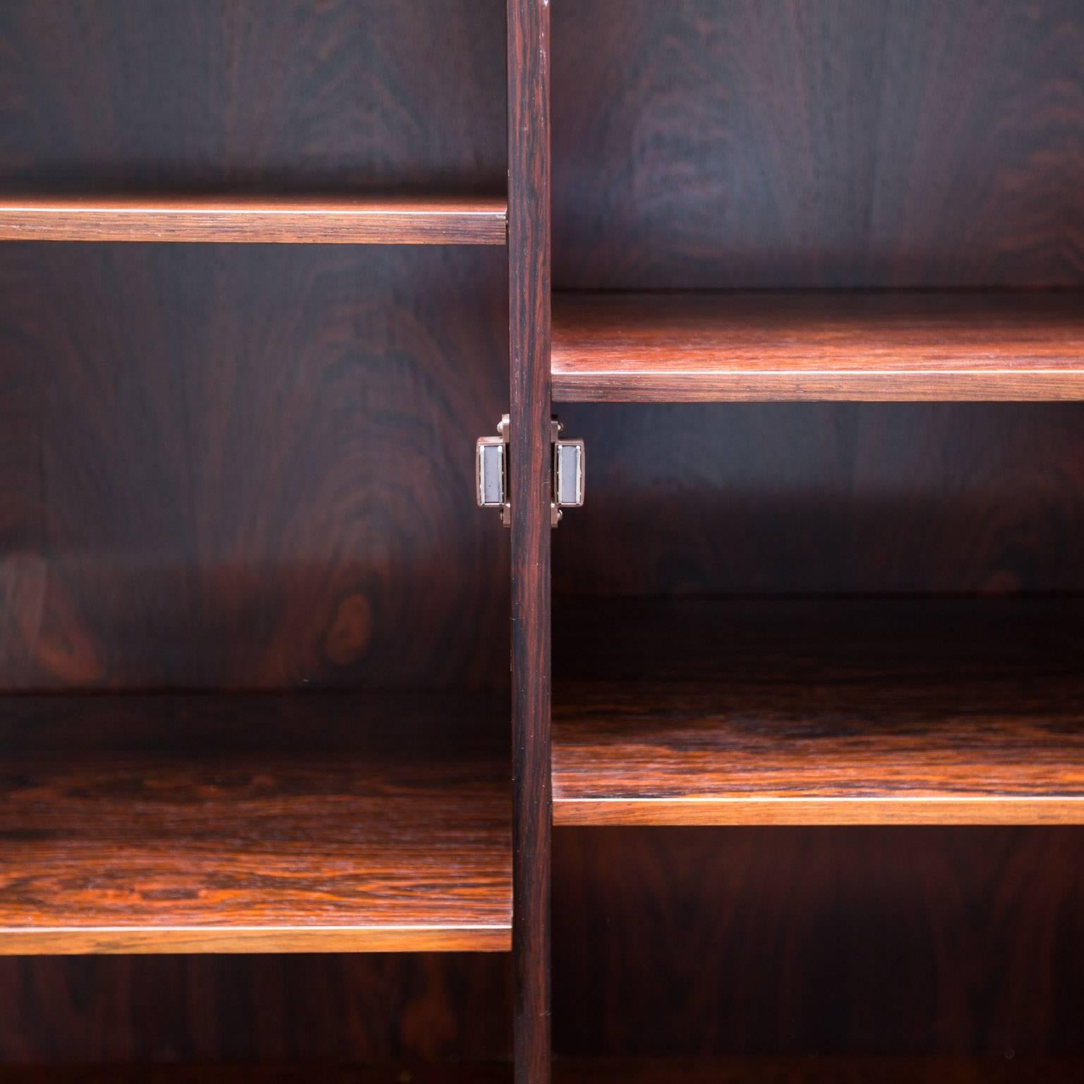 Nice clean cabinet in rosewood veneers with adjustable rosewood shelves. Bottom cabinet has locks with original keys.