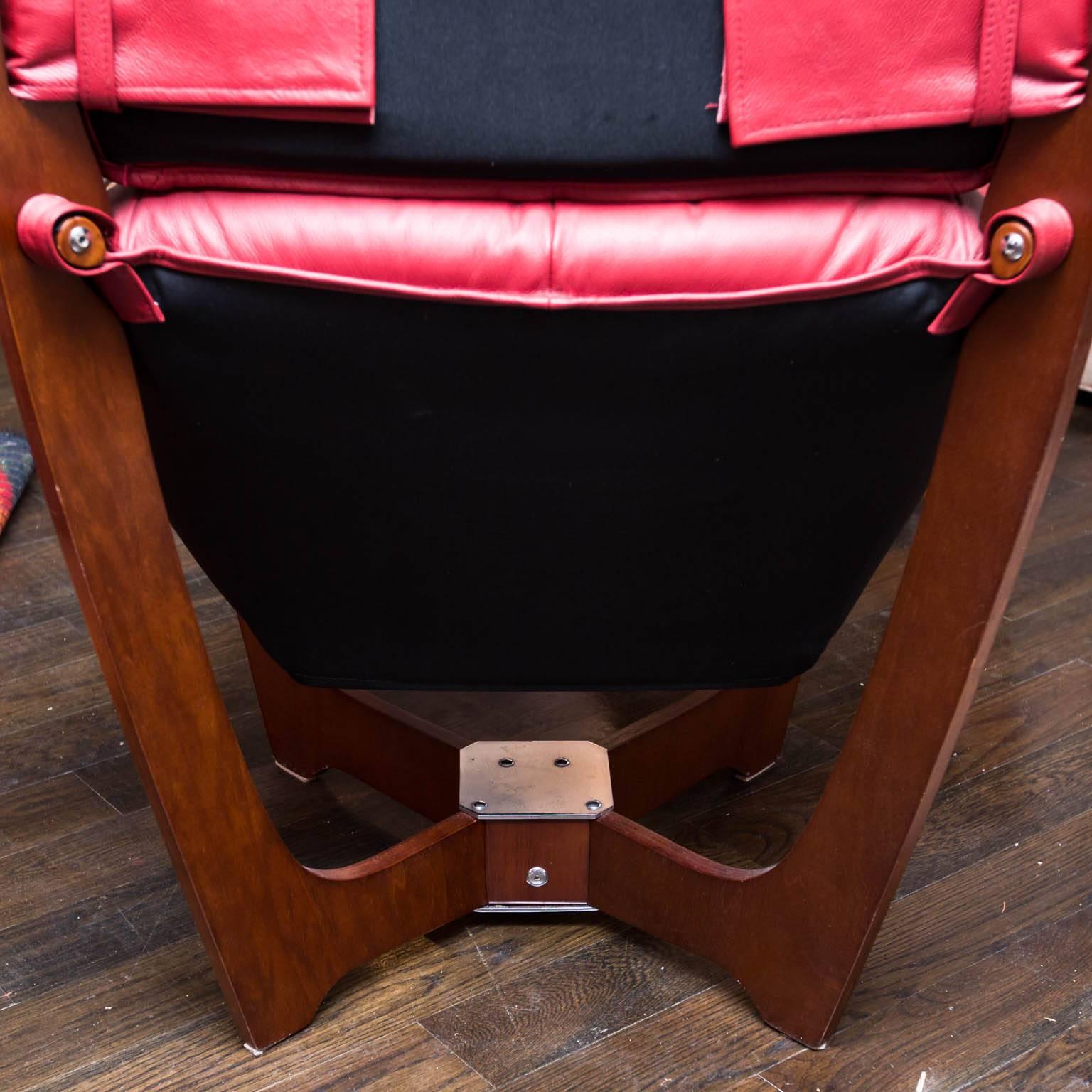 New old stock Luna chair and ottoman in oxblood leather. Walnut veneers.