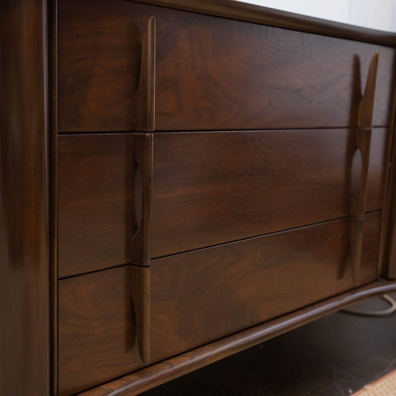 Newly refinished nine-drawer low dresser by United Furniture. Left and right drawers are set behind scalloped doors, while three generous centre drawers feature sculpted handles.