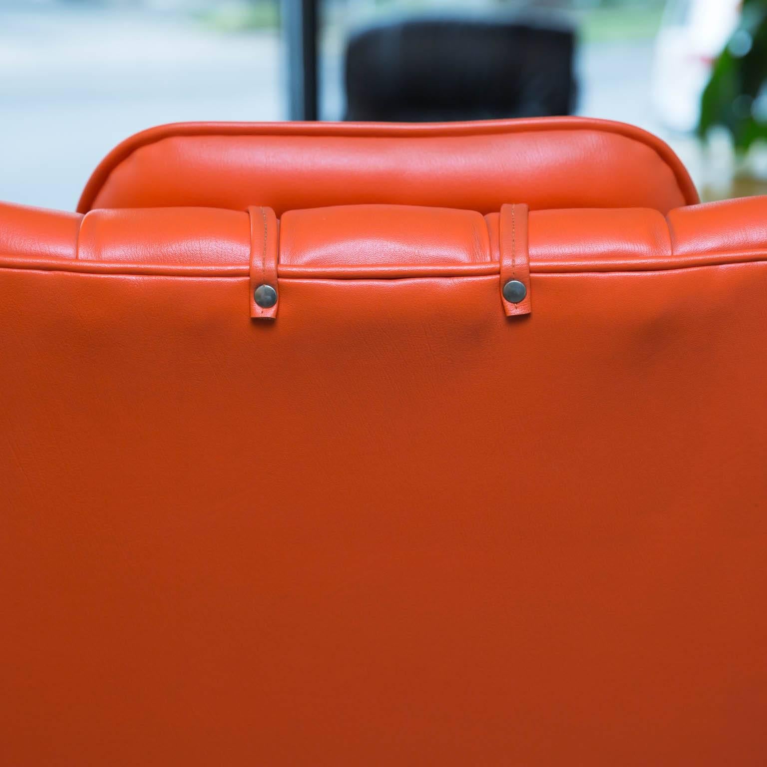 Iconic Mulhauser lounge chair in classic Mid-Century style orange naugahyde on a rare solid aluminum base.