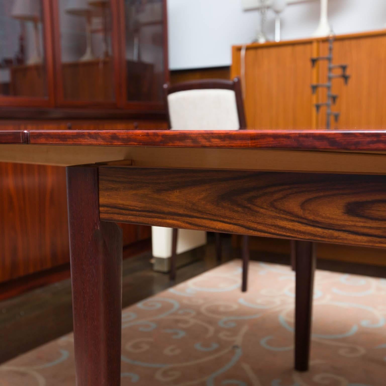 Brazilian rosewood dining room table that seats ten by Skovby Mobelfabrik featuring two leaves which are stored inside table. It measures ten and a half feet long with the leaves and just under six feet with leaves unextended.
 